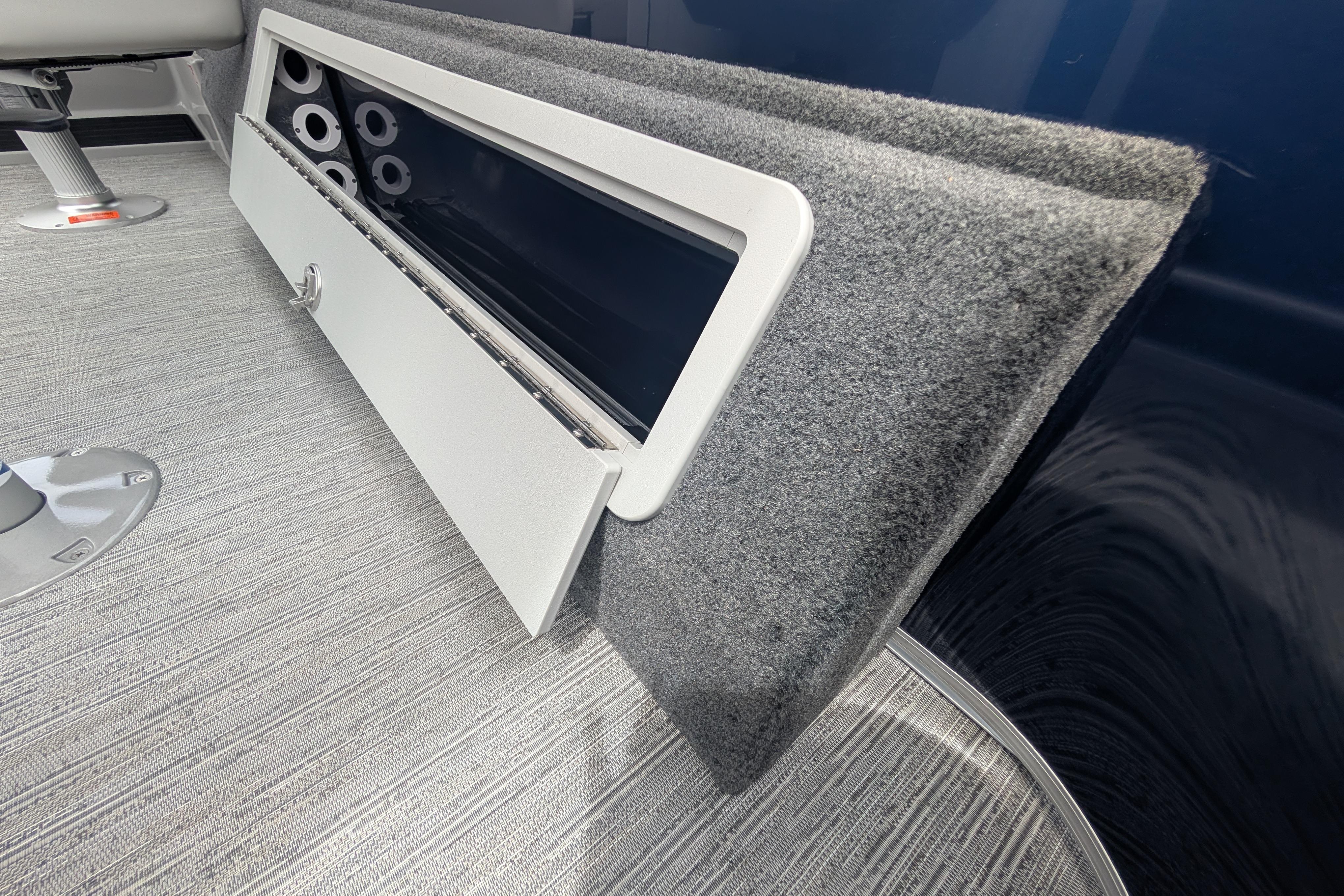 Interior view of 2026 Starcraft EX 20 F boat, featuring a storage compartment and carpeted flooring.