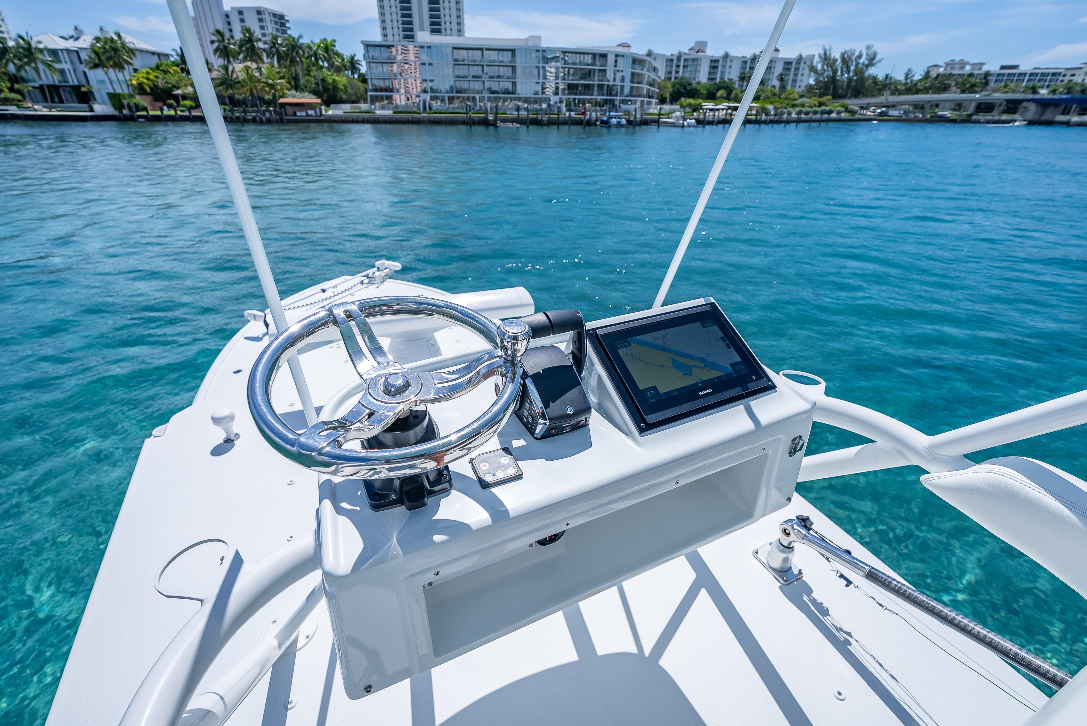 2016 Yellowfin 39 Offshore boat helm with steering wheel and navigation display on clear water.