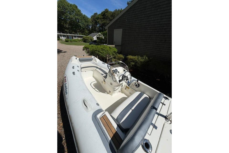 2016 Walker Bay Generation 450 DLX boat with seating and steering console, parked outdoors.