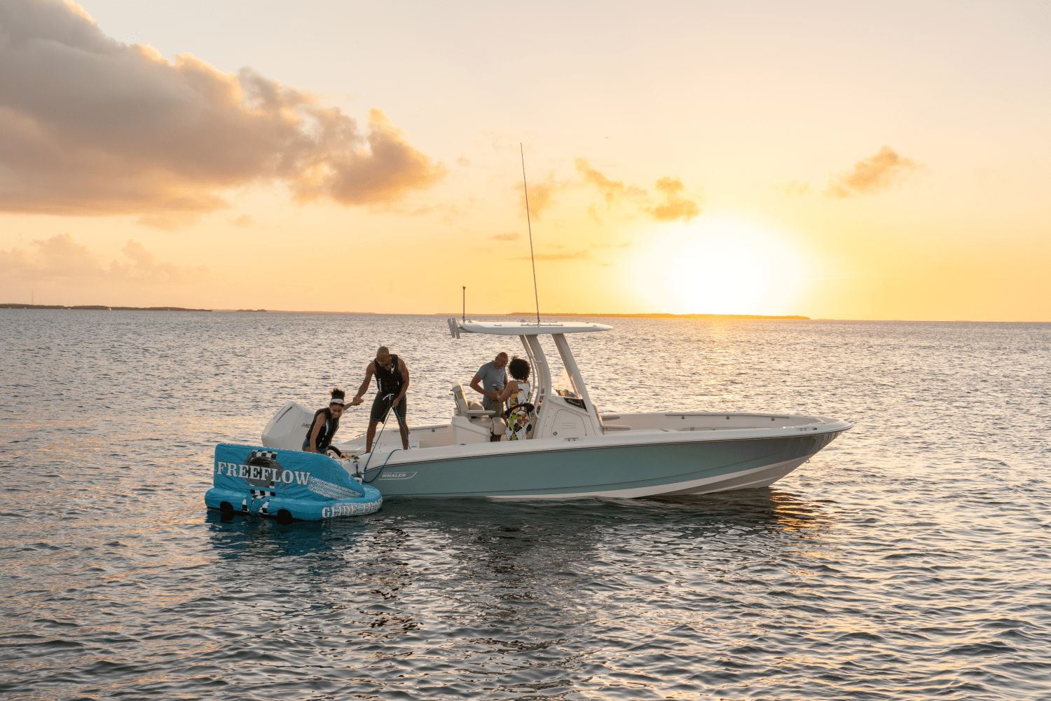 A Boston Whaler 25DA boat on the water at sunset.