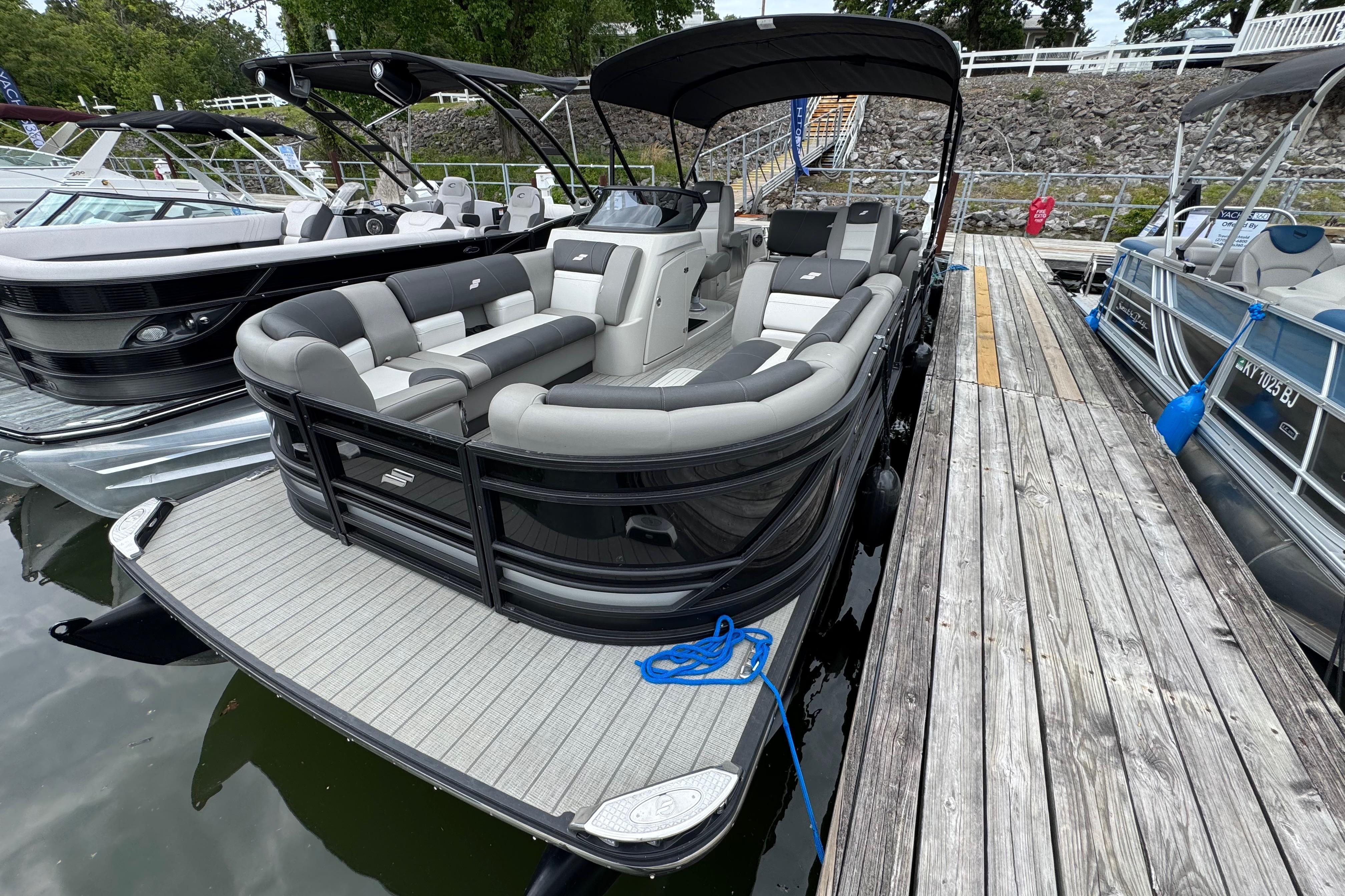 2023 Starcraft MX 25 DL DH pontoon boat docked, featuring sleek design and spacious seating.