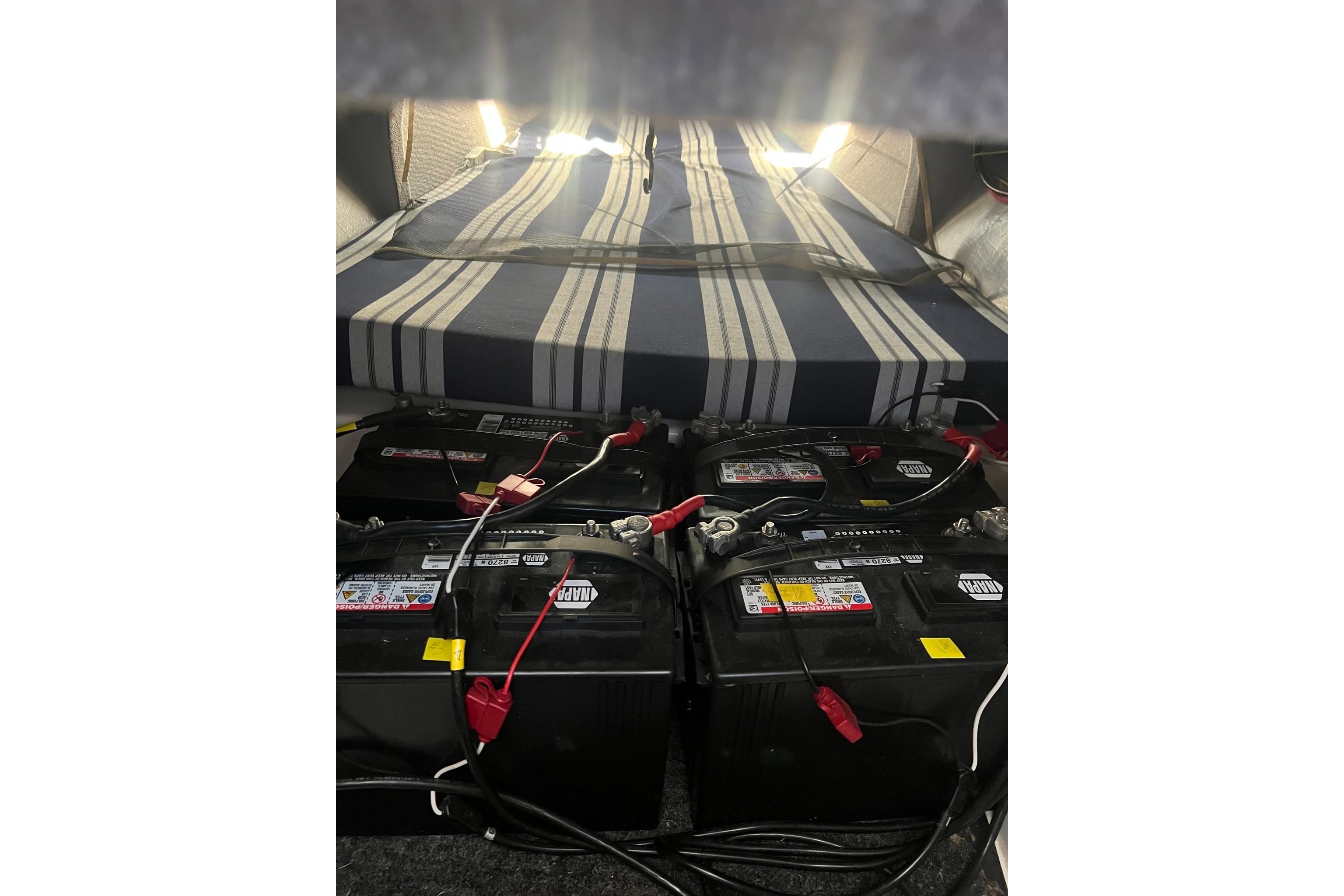 Interior of 1993 Corsair F-27 with batteries and striped mattress.