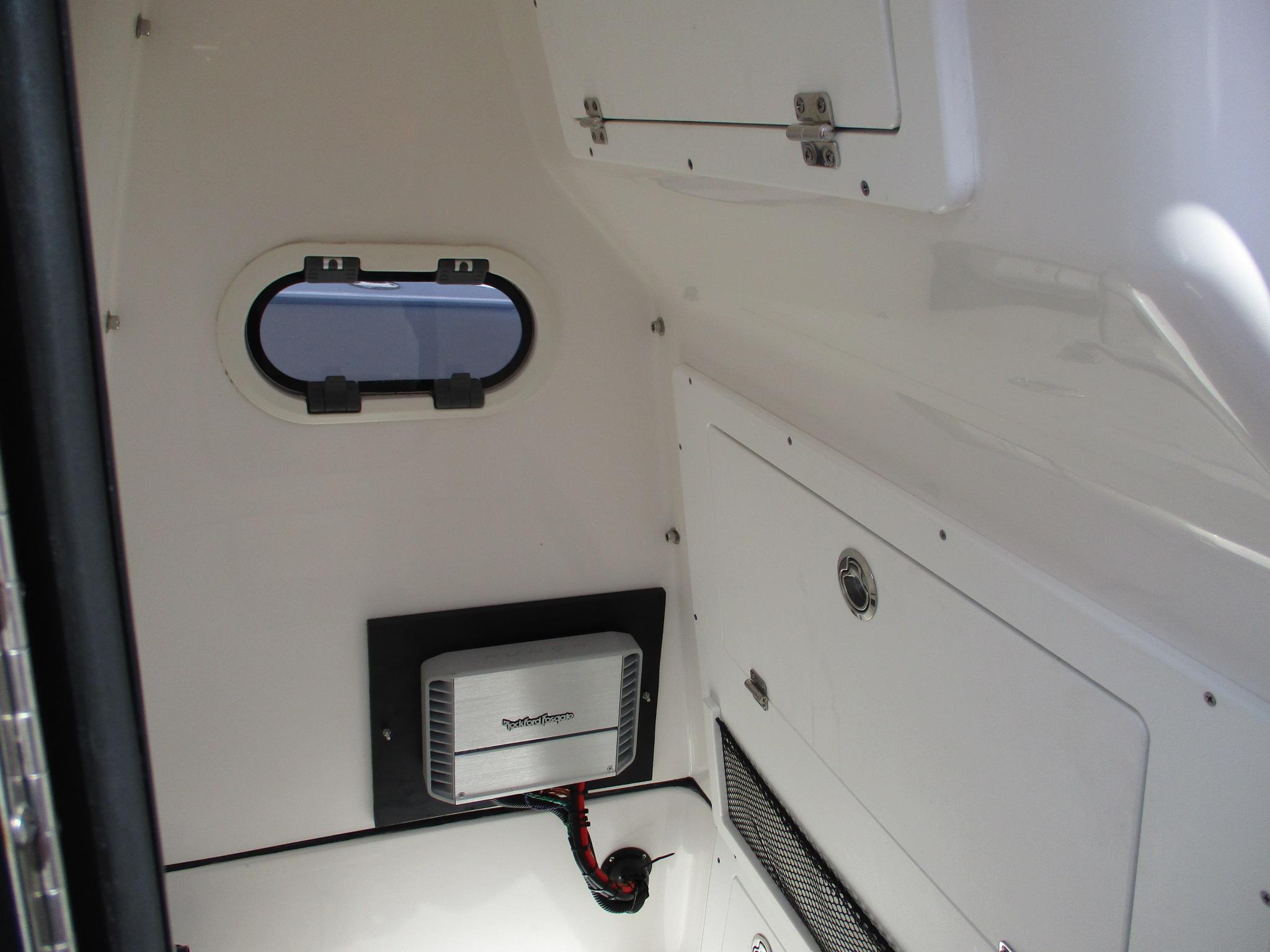 Interior of 2024 Blue Wave 2800 Makaira boat, featuring storage compartments and a small window.
