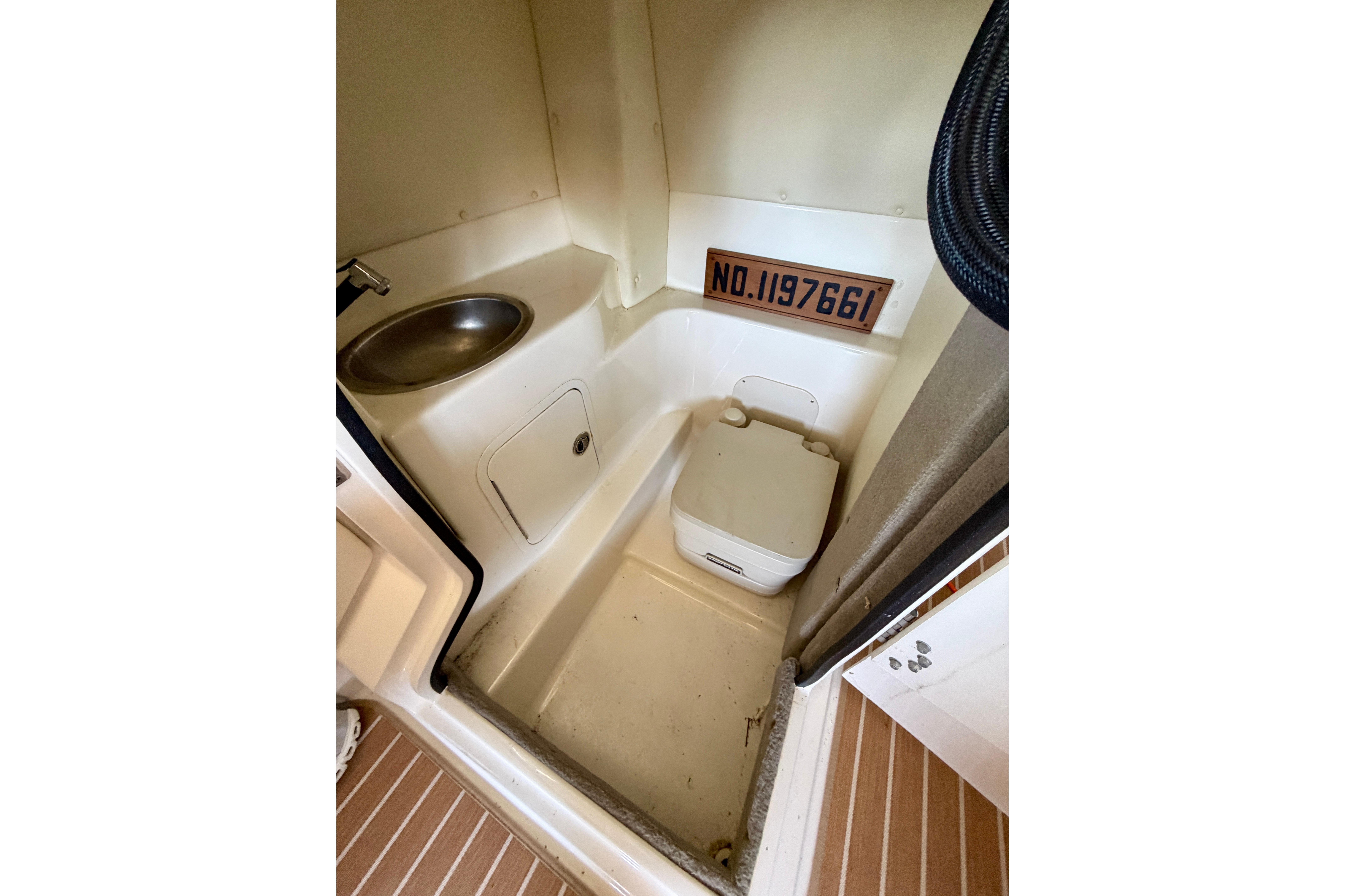 2007 Sea Ray 270 SLX boat bathroom with sink and portable toilet.