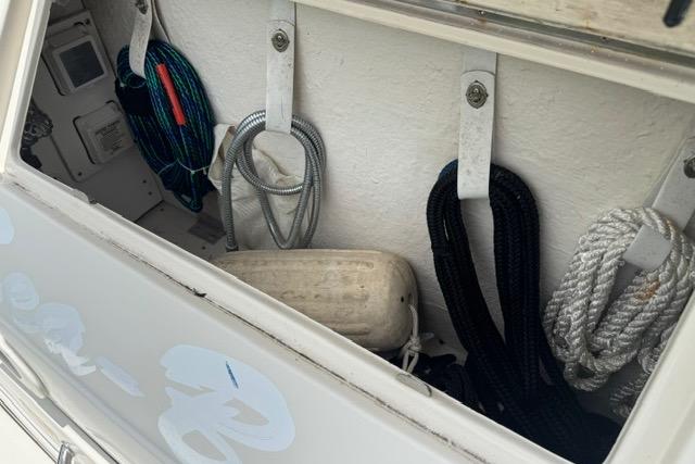 Storage compartment of a 2004 Sea Ray 240 Sundancer with ropes and equipment.