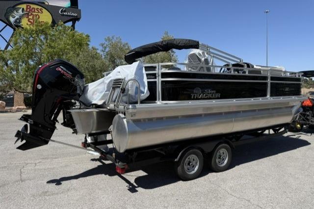 2026 Sun Tracker Fishin' Barge 20 DLX pontoon boat on trailer, outdoor setting.