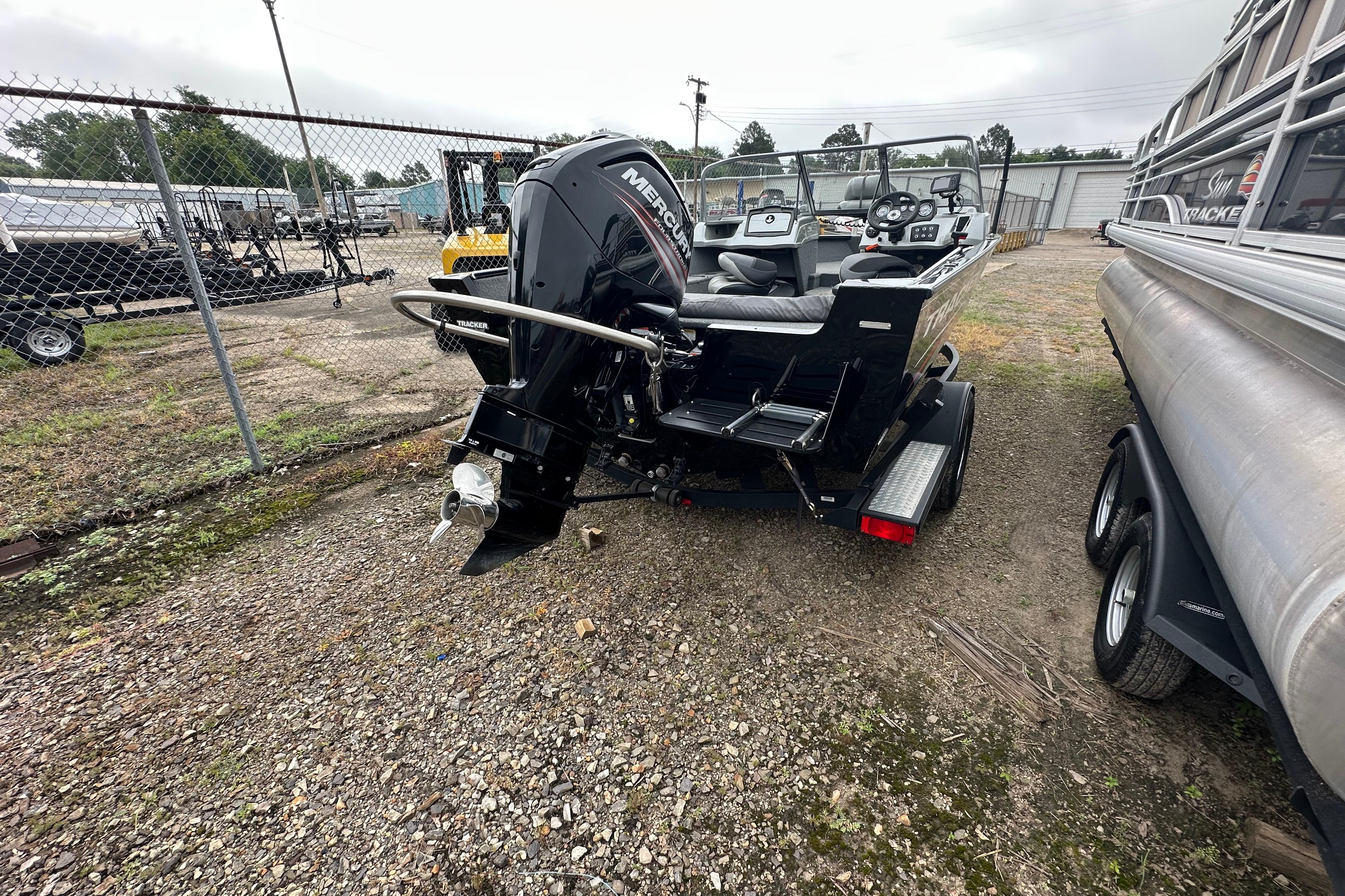 2018 Tracker Pro Guide V-175 Combo boat with Mercury outboard motor in a storage yard.