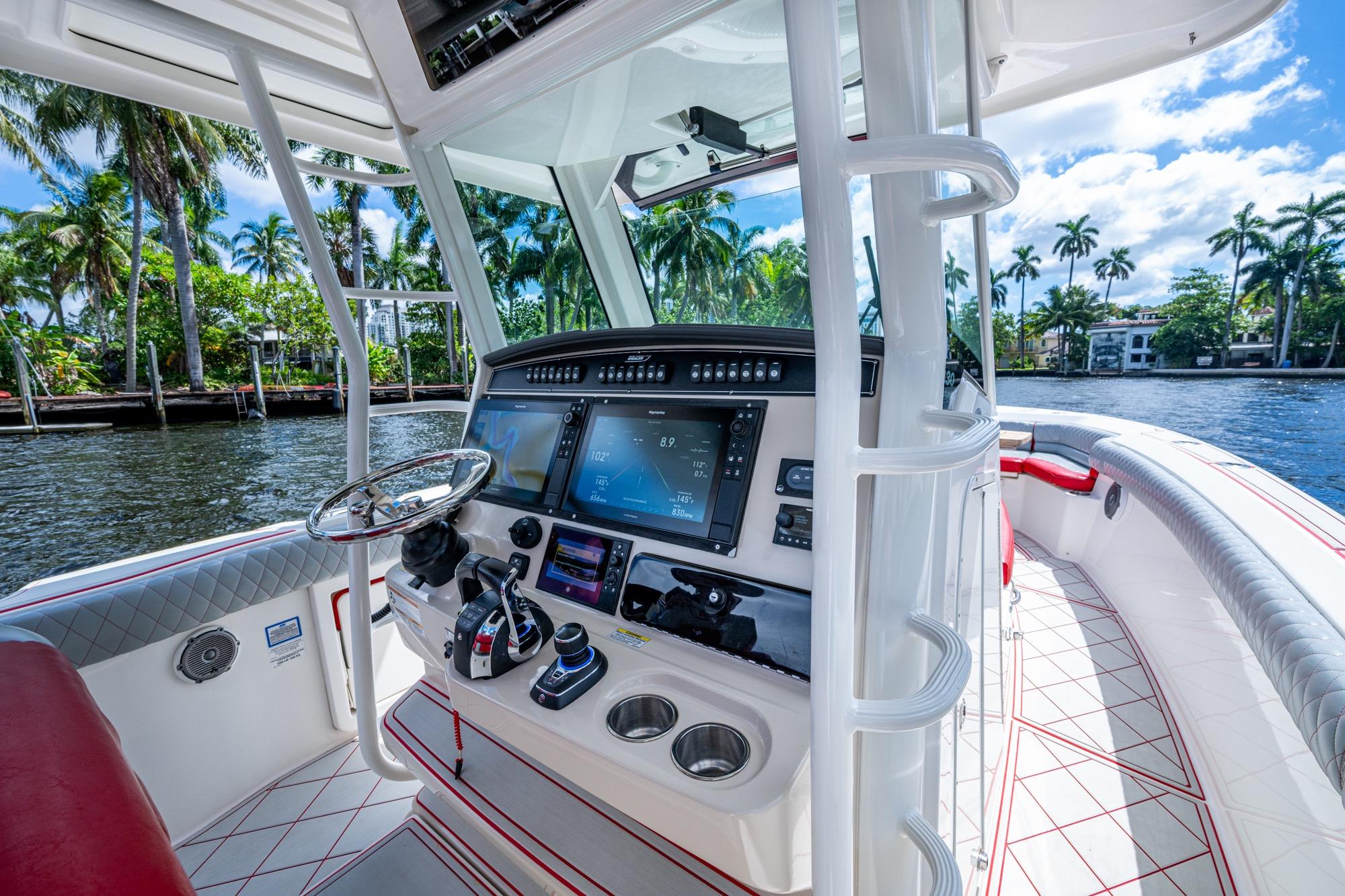 2018 Boston Whaler 330 boat cockpit with advanced navigation system and scenic waterfront view.