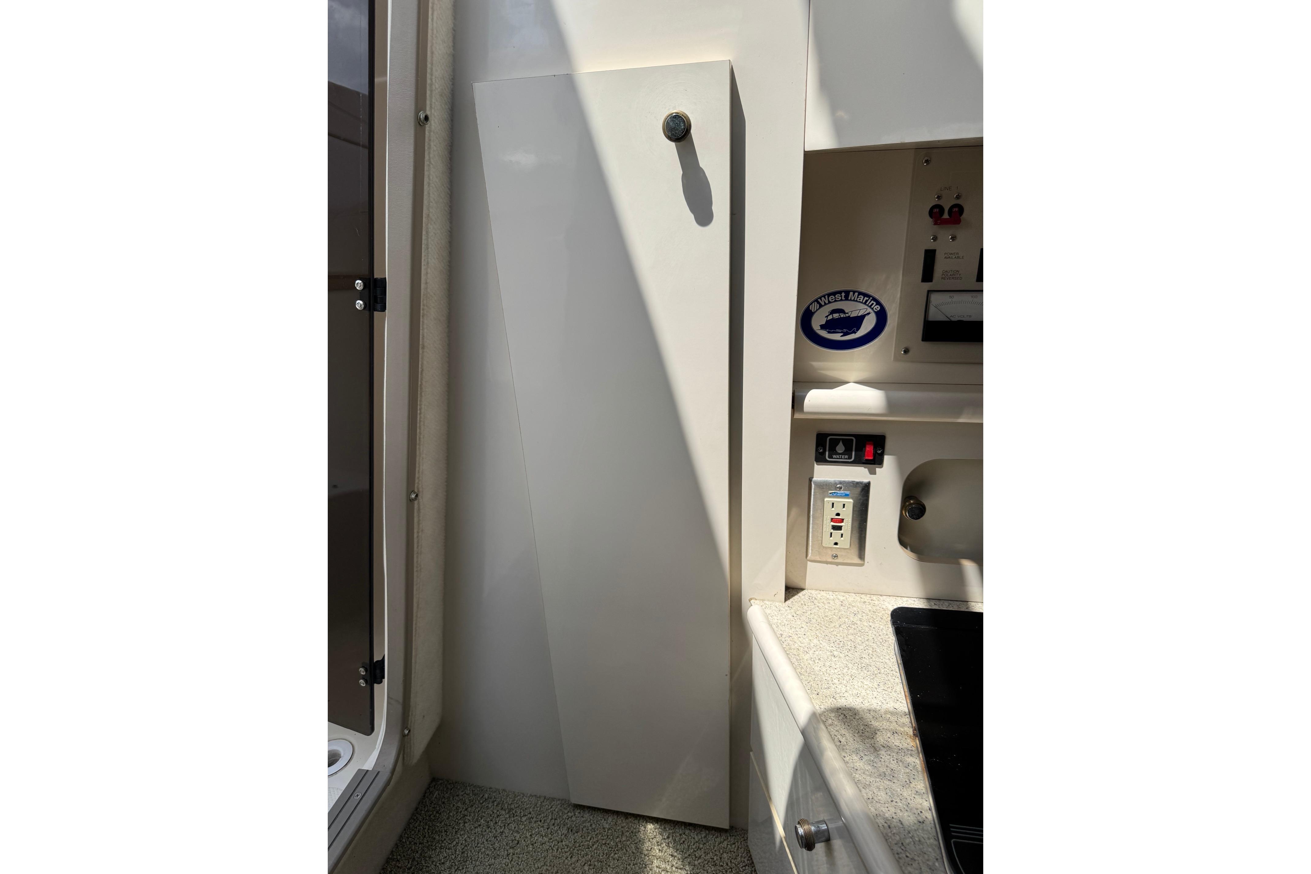 Interior view of a 2000 Maxum 2400 SCR boat, featuring a cabinet and control panel.