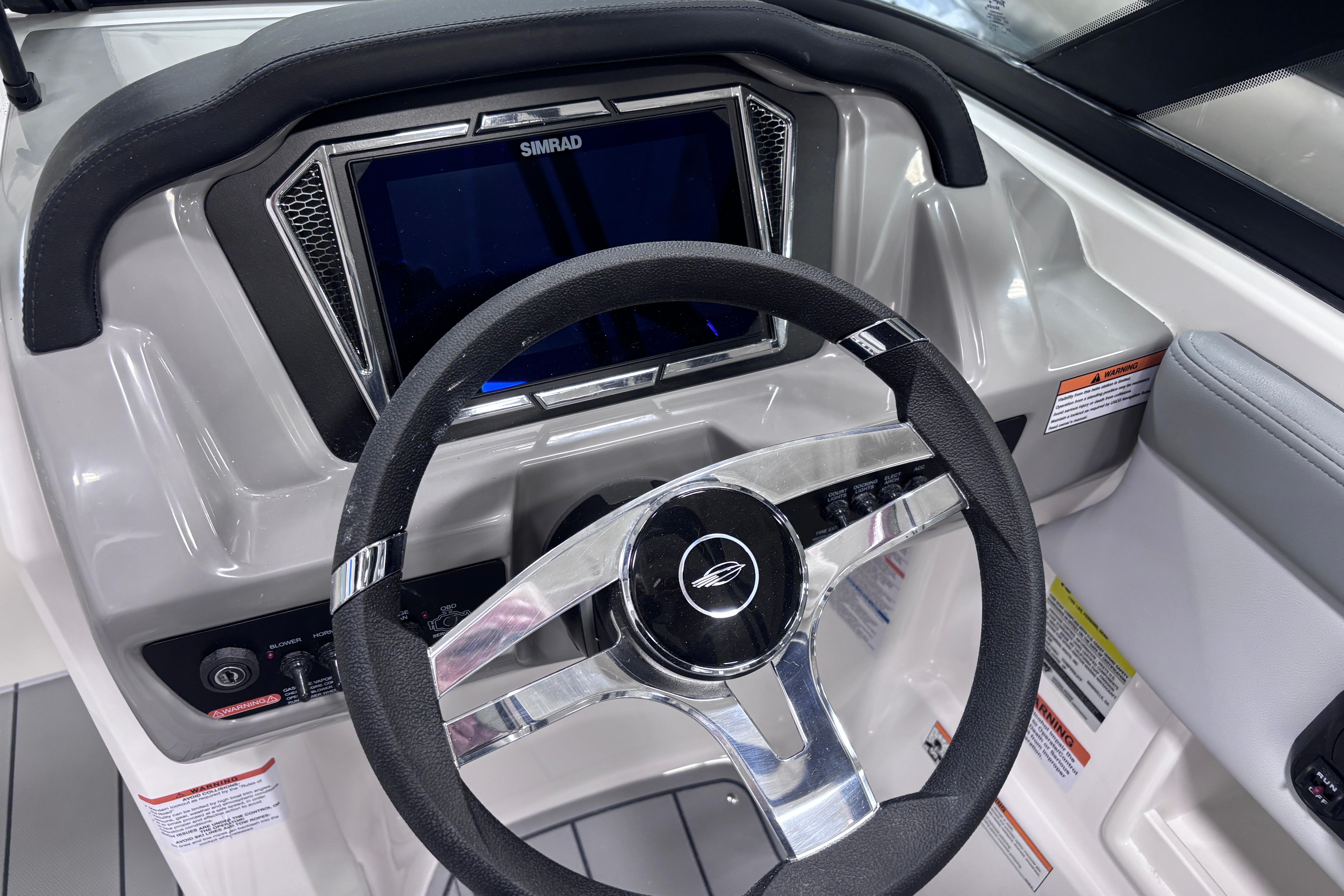 2026 Chaparral 23 SSi boat dashboard with steering wheel and Simrad display.