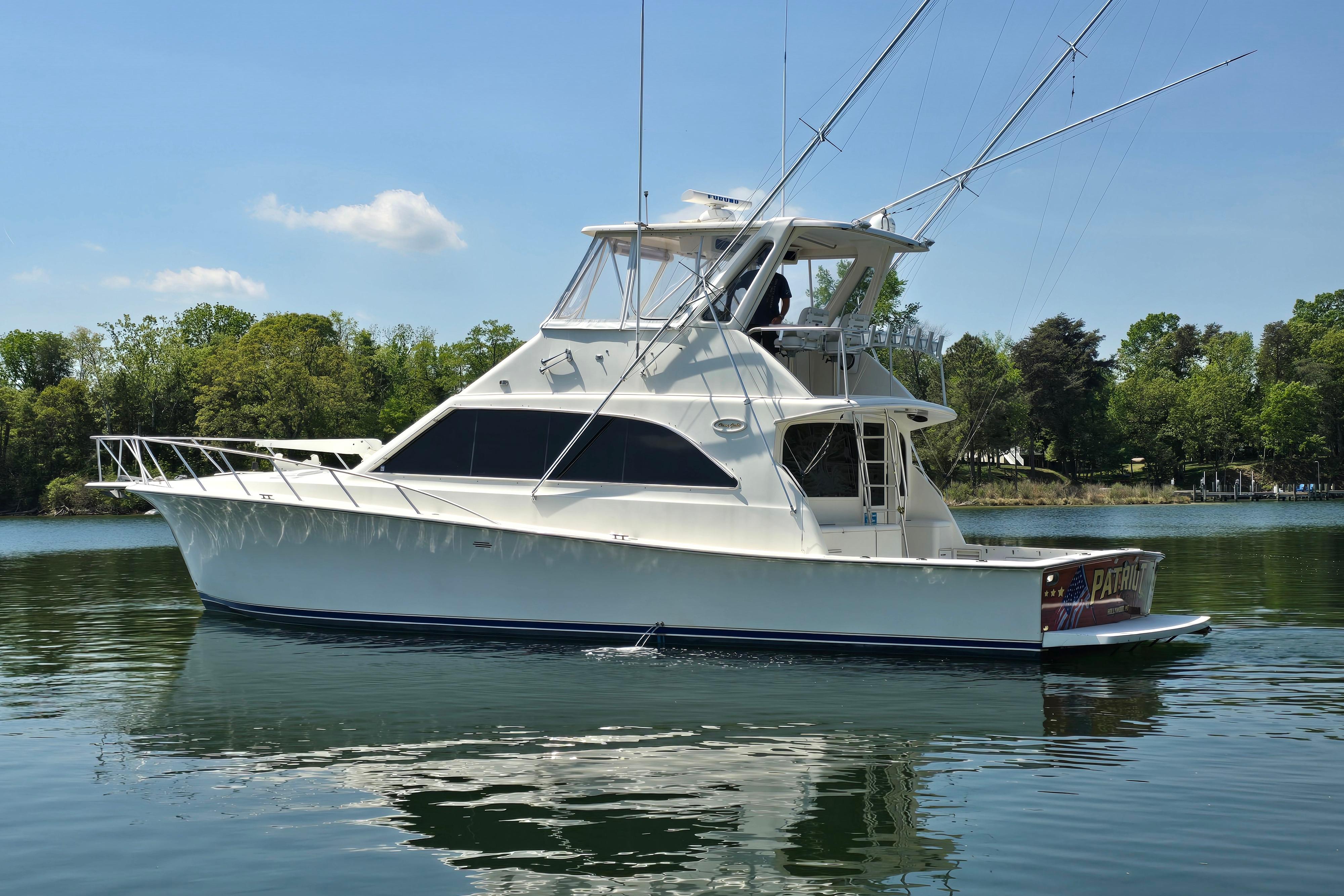 1993 Ocean Yachts 53 Super Sport boat on calm water, surrounded by lush greenery.