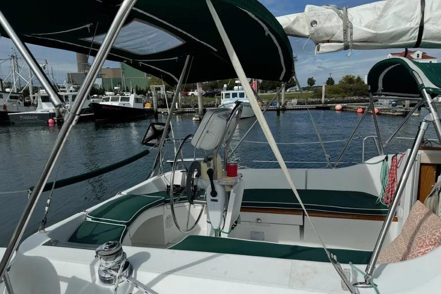 Cockpit view of a 2000 Beneteau Oceanis 321 sailboat docked in a marina.