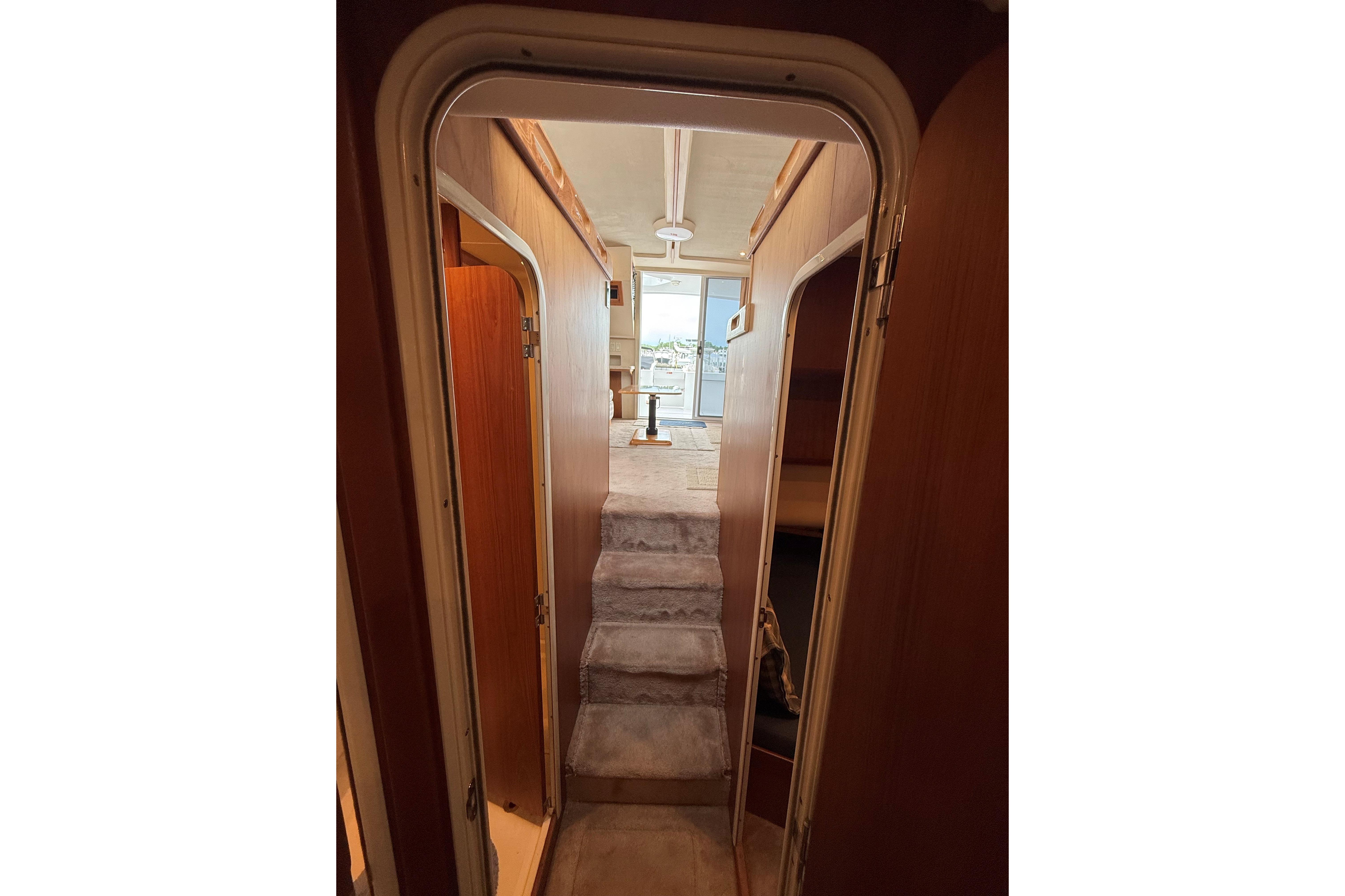 Interior view of 1999 Mainship 350 Trawler, featuring a narrow hallway and carpeted steps.