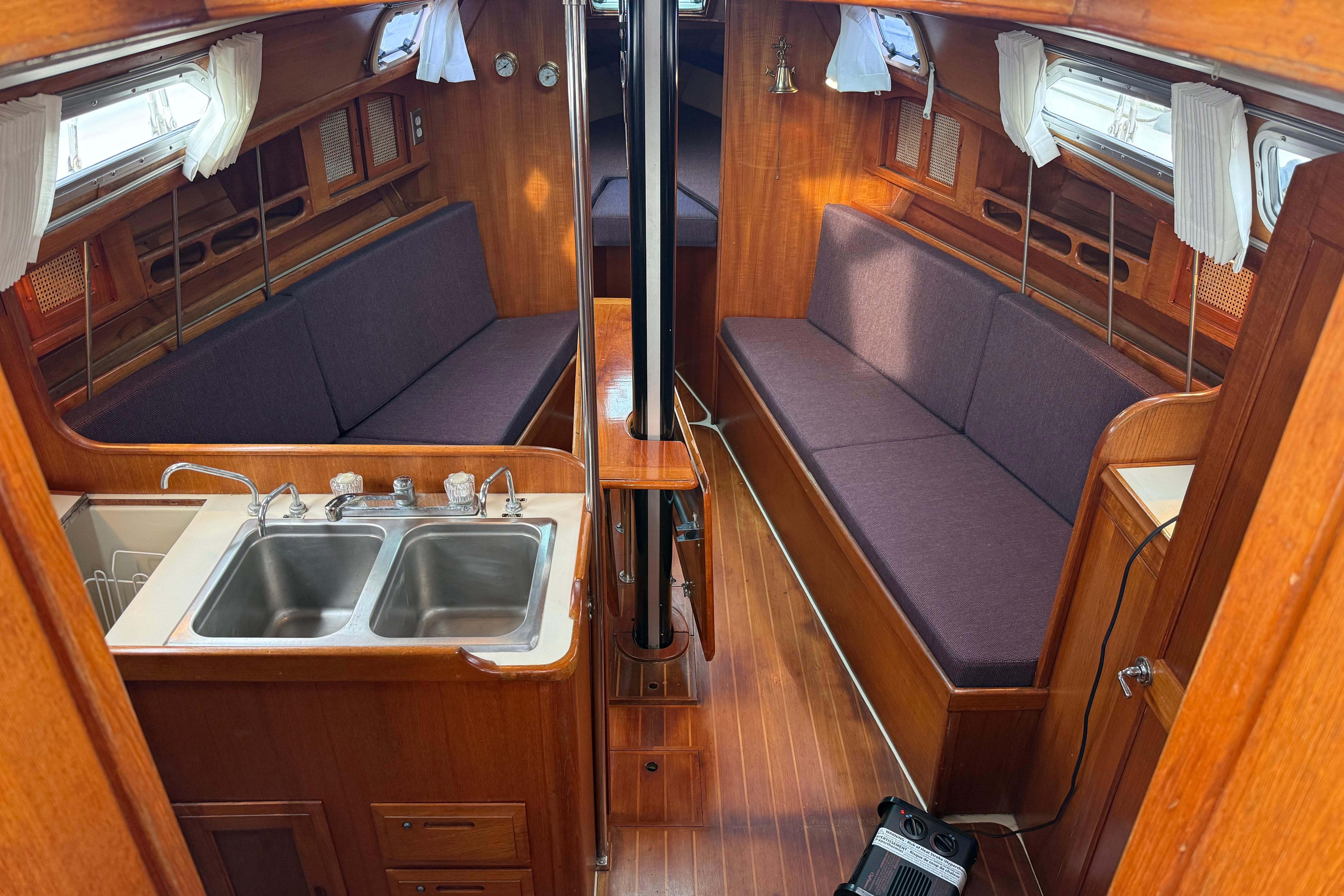 Interior of 1988 Ericson 32-200 sailboat with wooden finish and dual sinks.