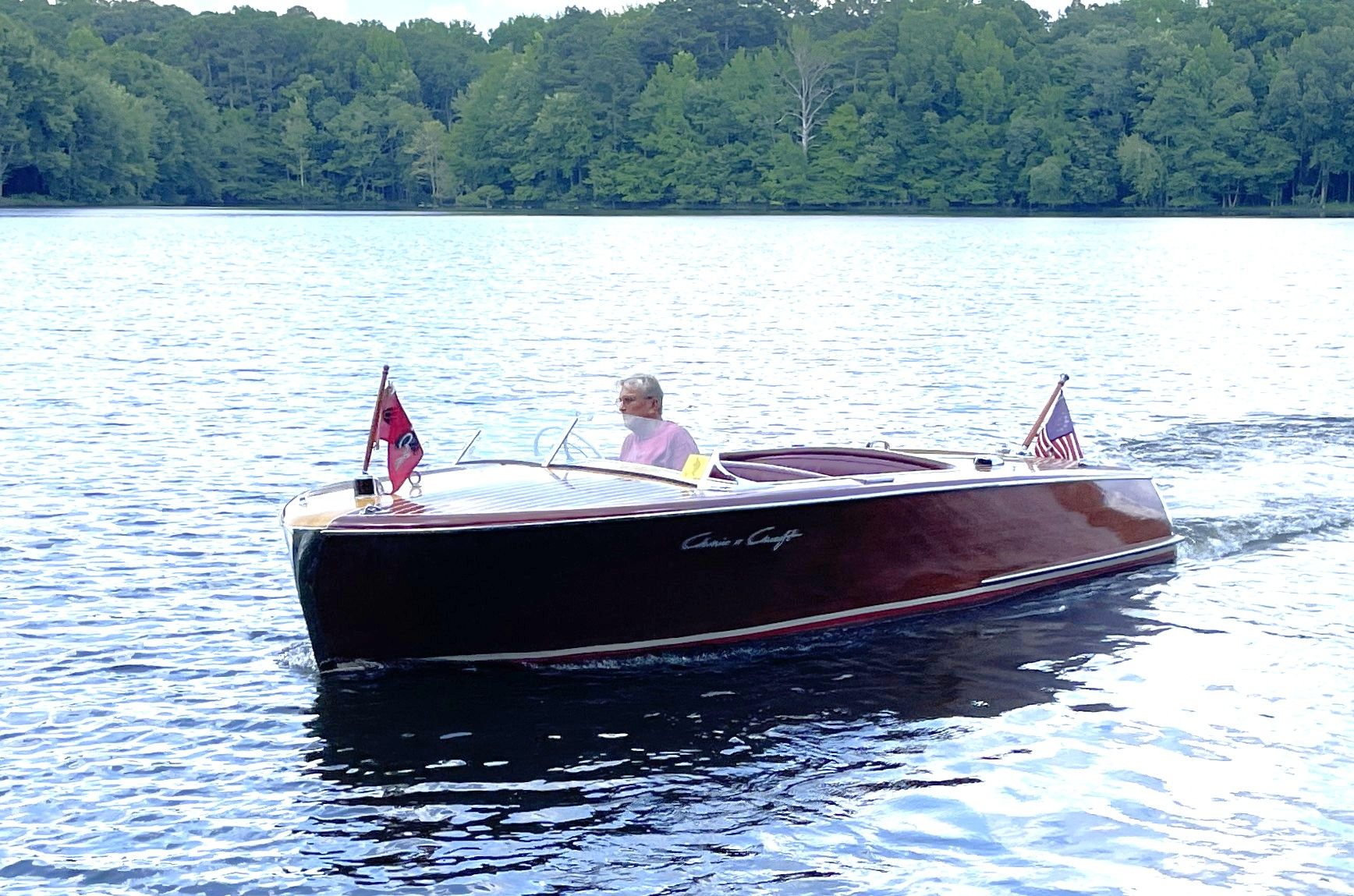 1954 Chris-Craft Riviera on a serene lake.