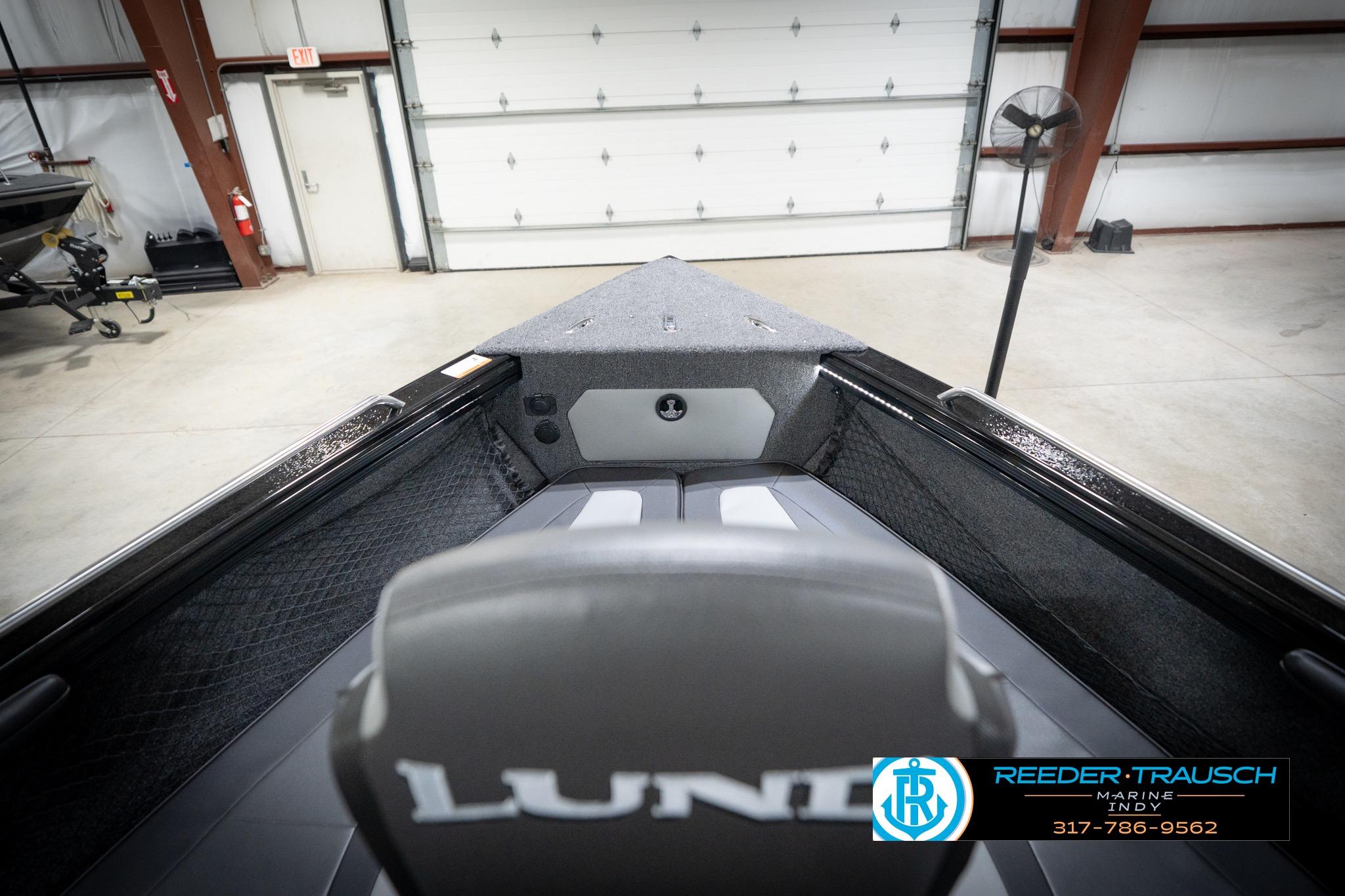 2026 Lund 2275 Baron boat interior in a showroom, featuring seating and storage.