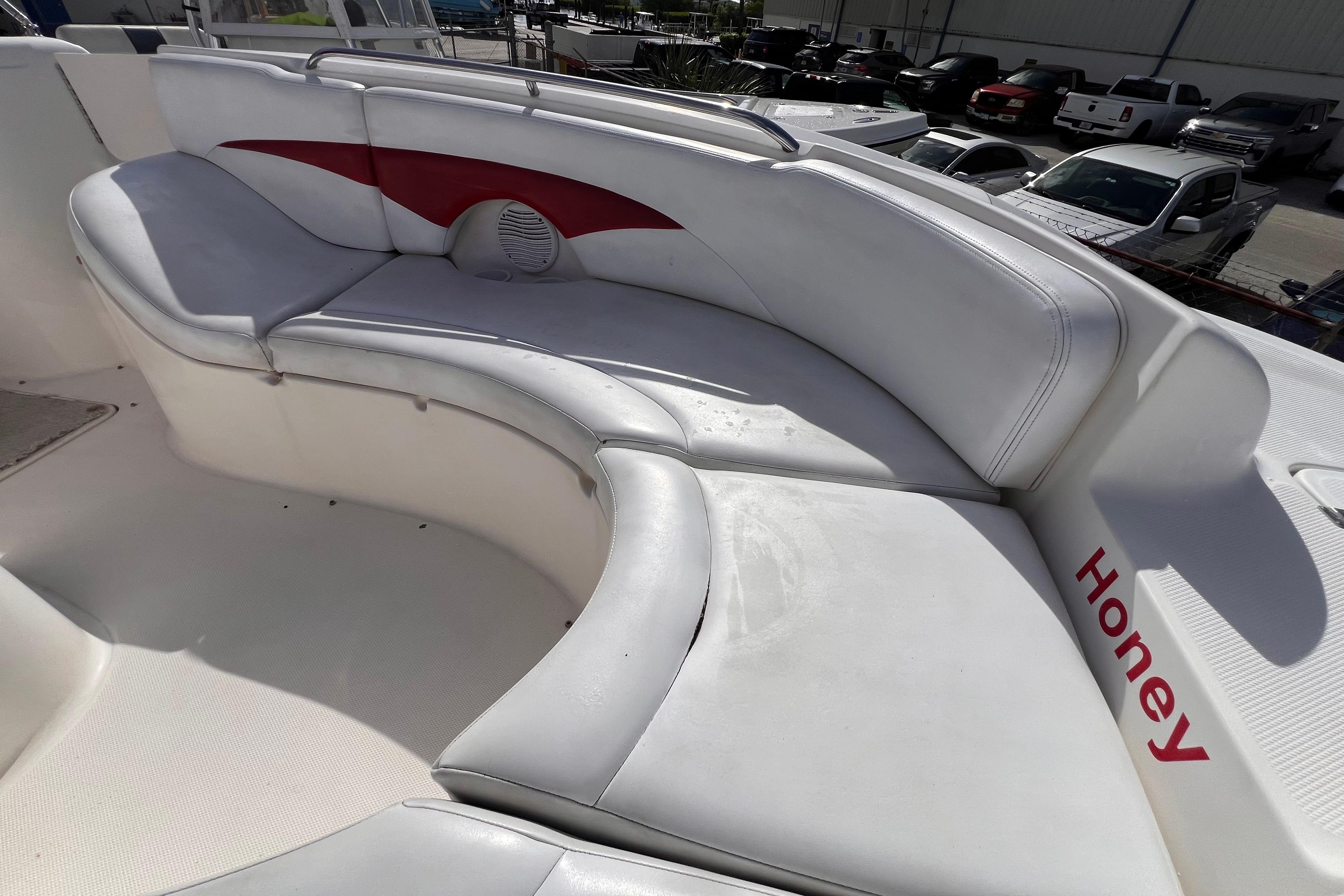 2002 Chaparral 232 Sunesta boat with white and red seating, labeled "Honey."