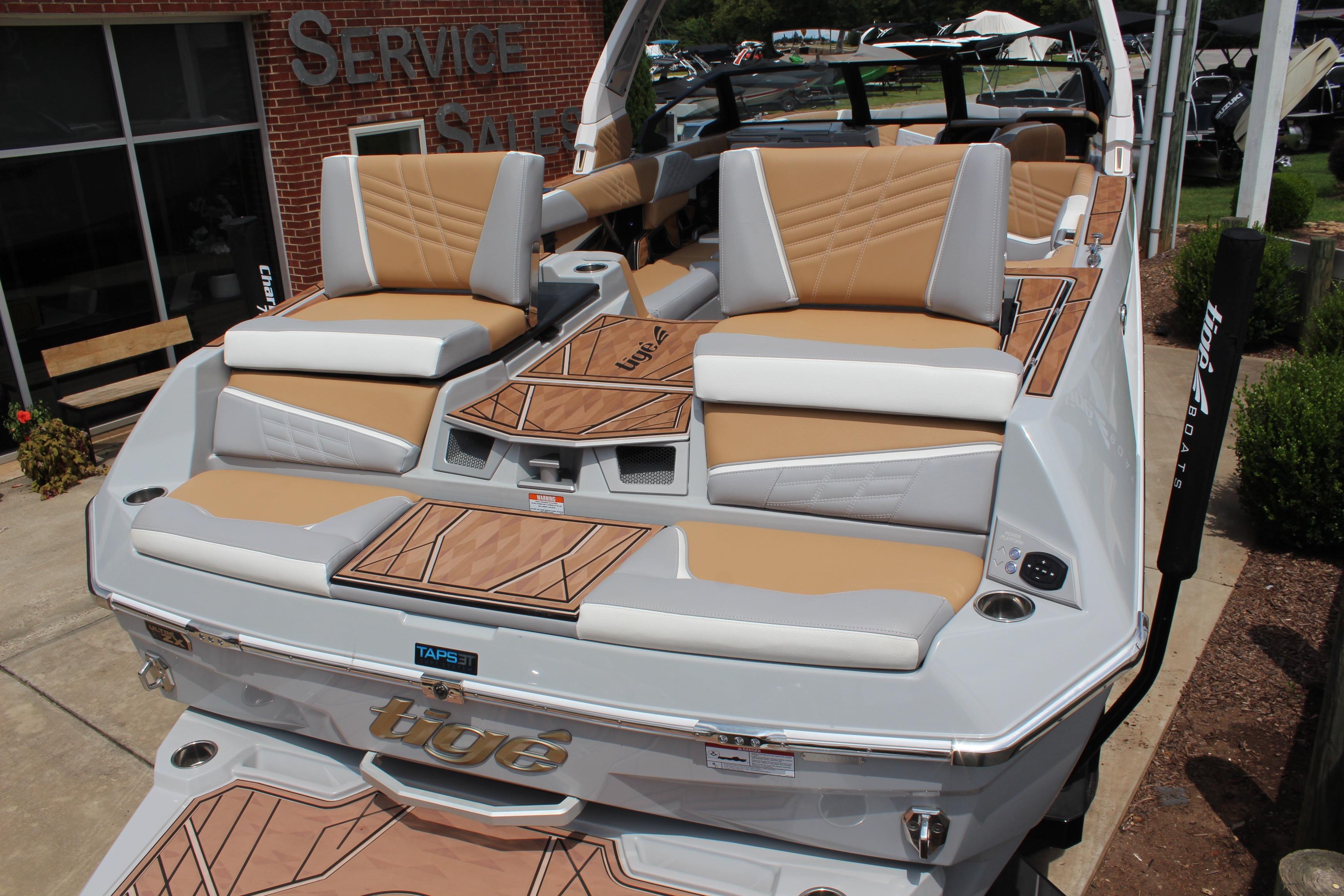 2024 Tigé Ultré 25ZX boat with tan and white seating, displayed outdoors.