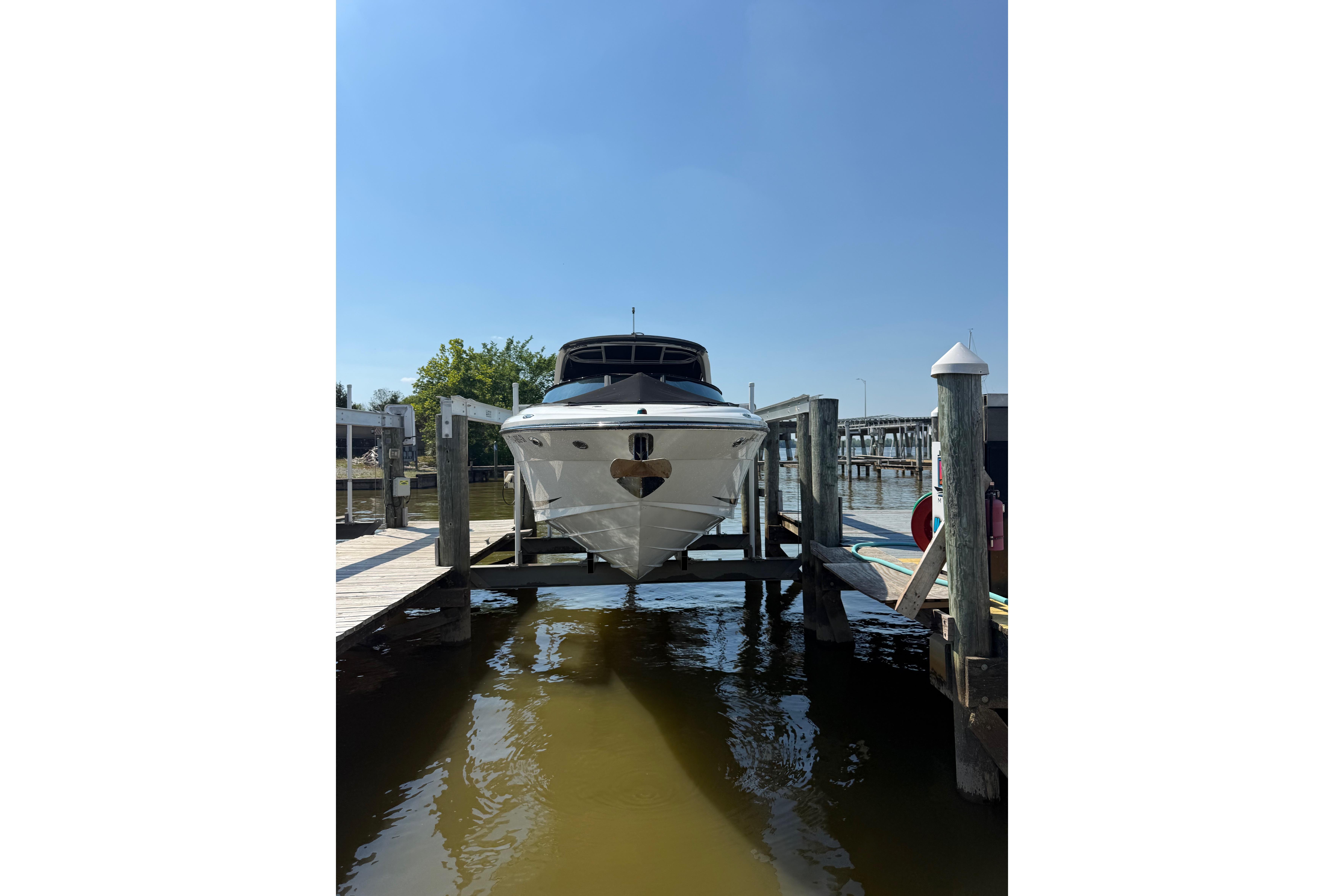 2011 Sea Ray 270 SLX boat docked at a marina under clear blue skies.
