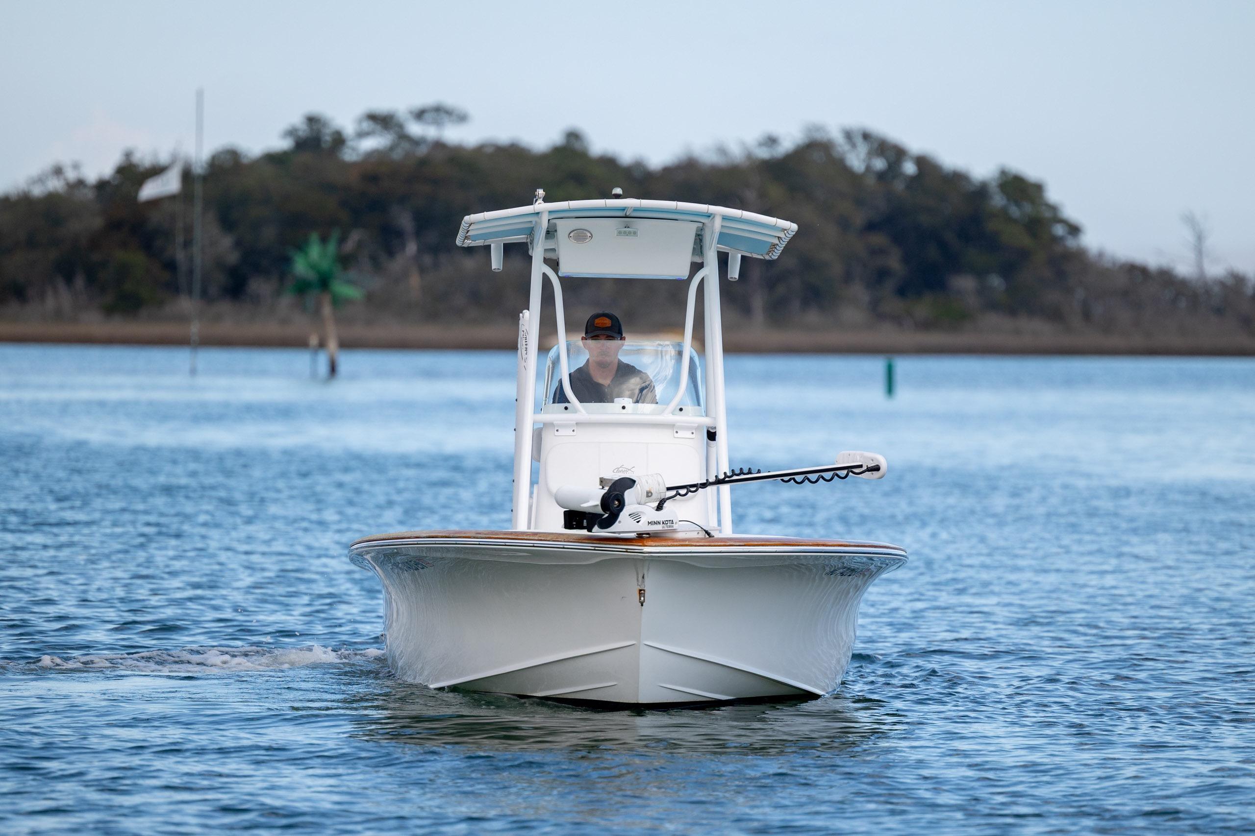 2017 Chaos 21 Tarpon Bay boat cruising on calm water with scenic background.
