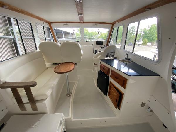 Interior of a 2015 Eastern 27 Islander with seating, table, and kitchenette.