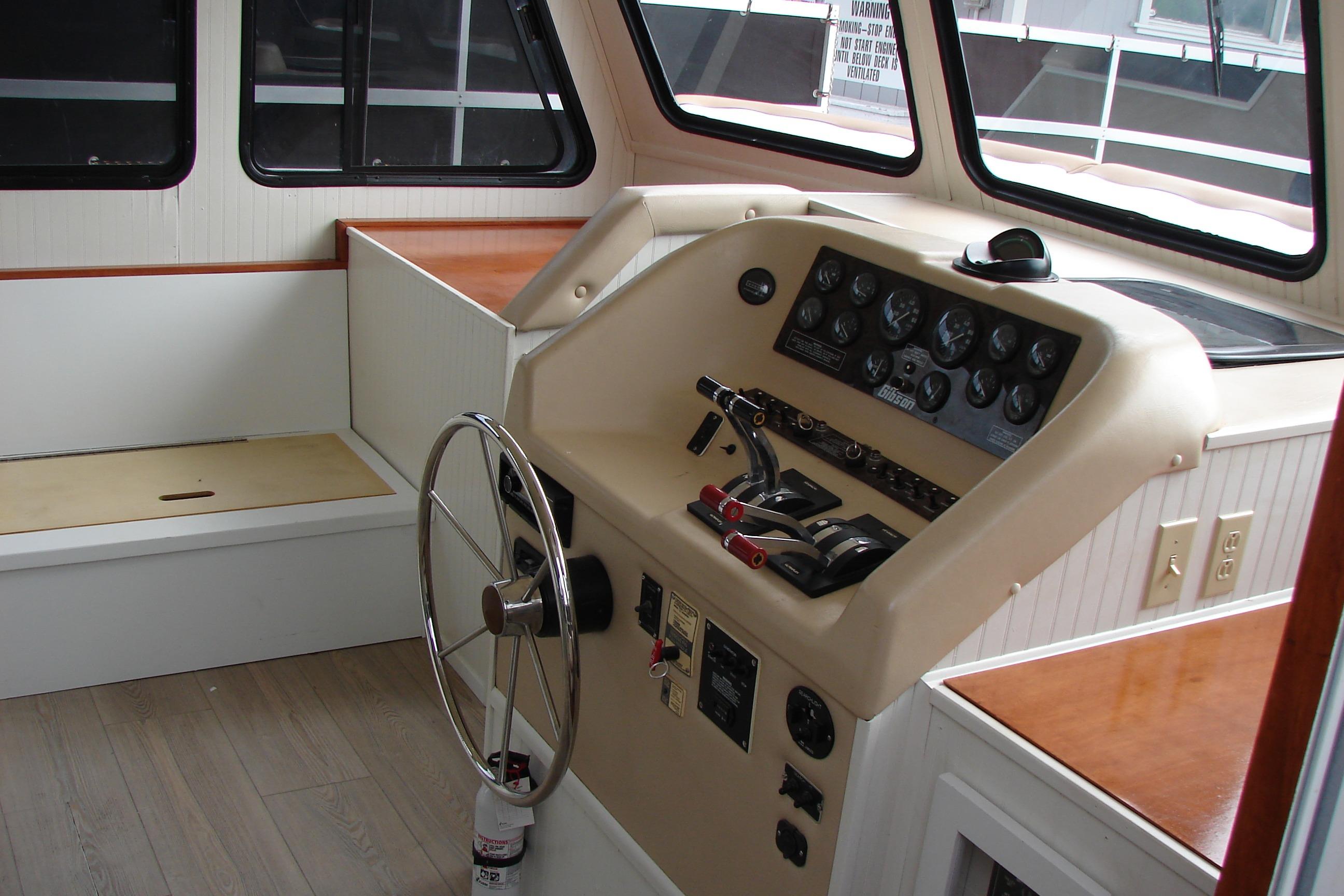 1997 Gibson 47 Sport Houseboat helm with steering wheel and control panel.