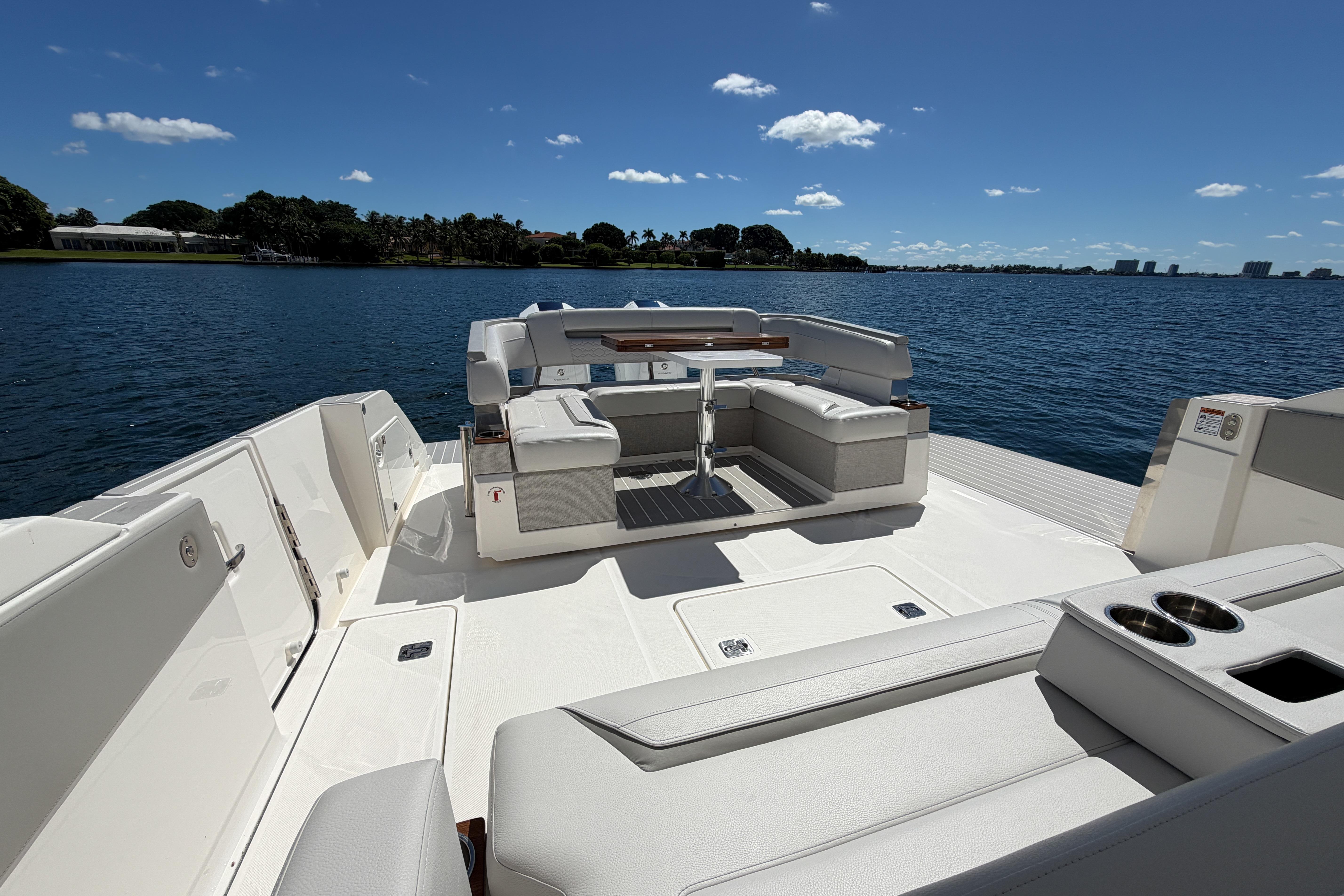 2024 Tiara Yachts 43 LS luxury deck with seating, overlooking serene water and clear sky.