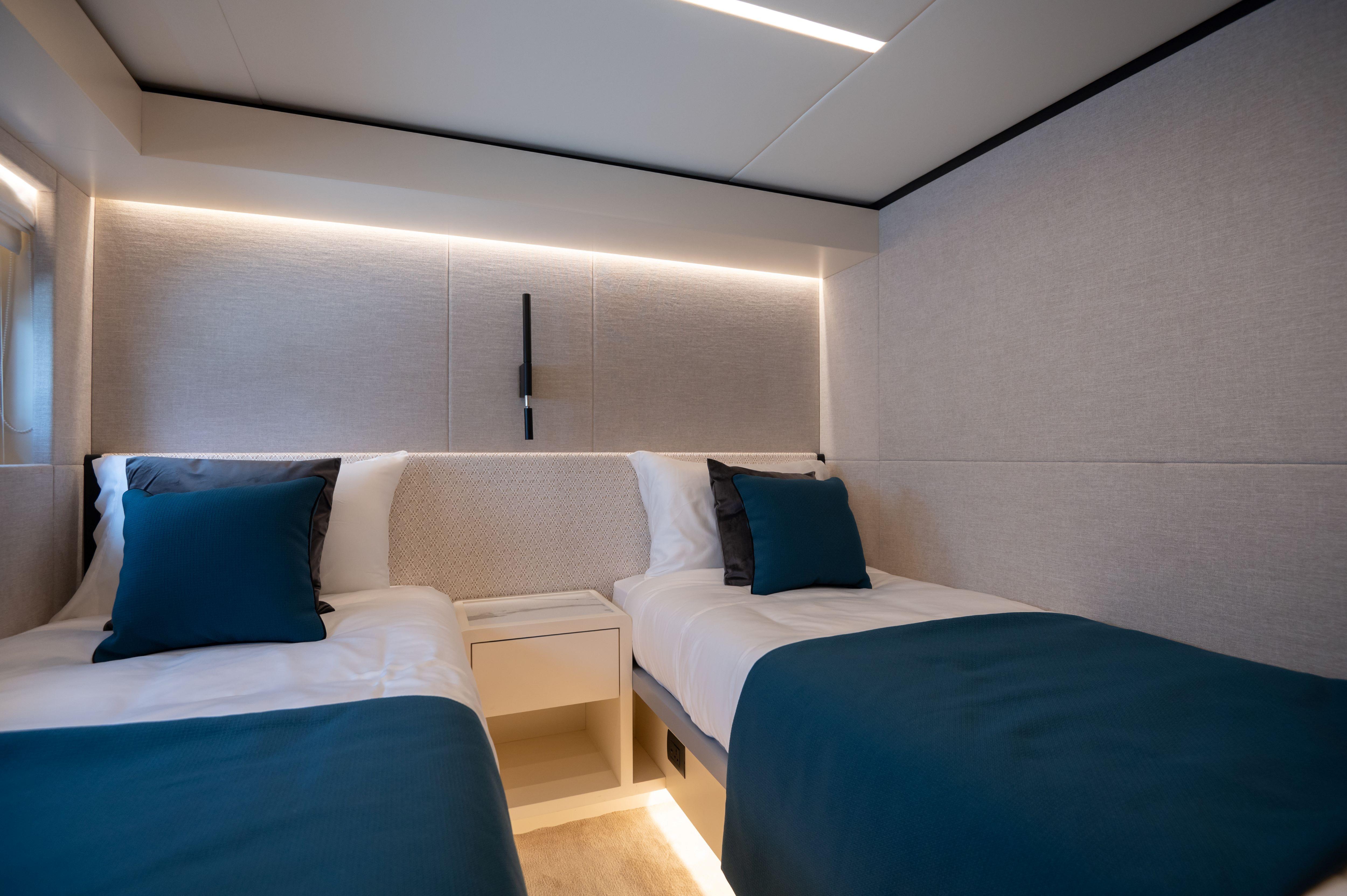 Luxurious twin bedroom in 2025 Nomad 70 SUV yacht, featuring modern design and ambient lighting.