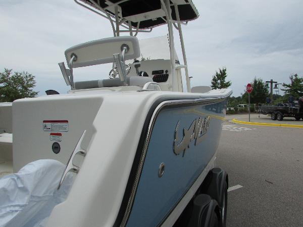 2023 Mako 214 CC boat, side view, parked on a trailer.