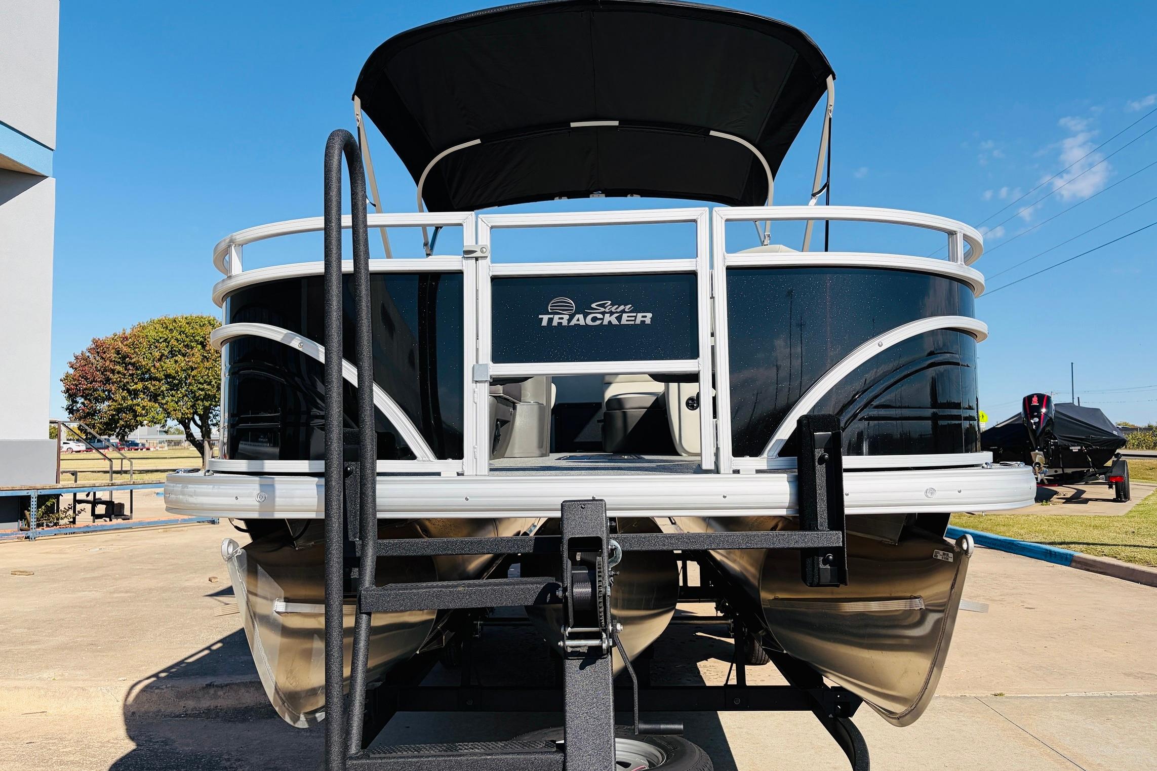 2026 Sun Tracker Fishin' Barge 22 XP3 pontoon boat on trailer, outdoor display.