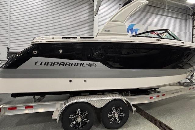 2026 Chaparral SSX 8 boat on trailer in showroom, sleek black and white design.