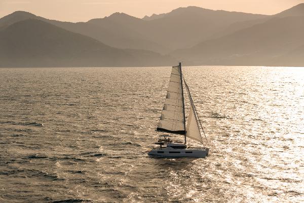 Sailing Lagoon 51 ICONIC catamaran on serene waters at sunset, 2025 model.