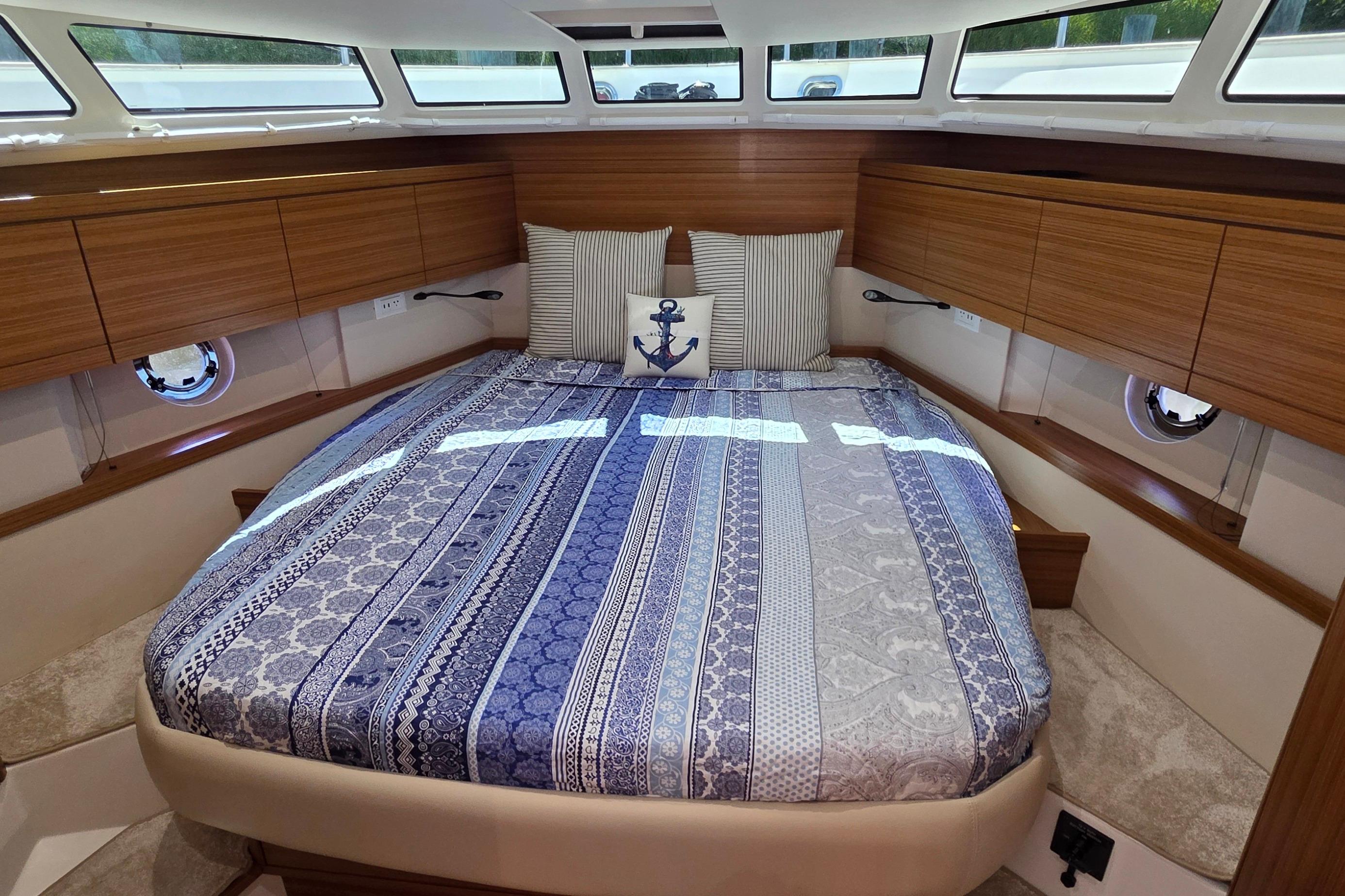 Luxurious cabin interior of 2023 Greenline 40 yacht with stylish bedding and wood accents.
