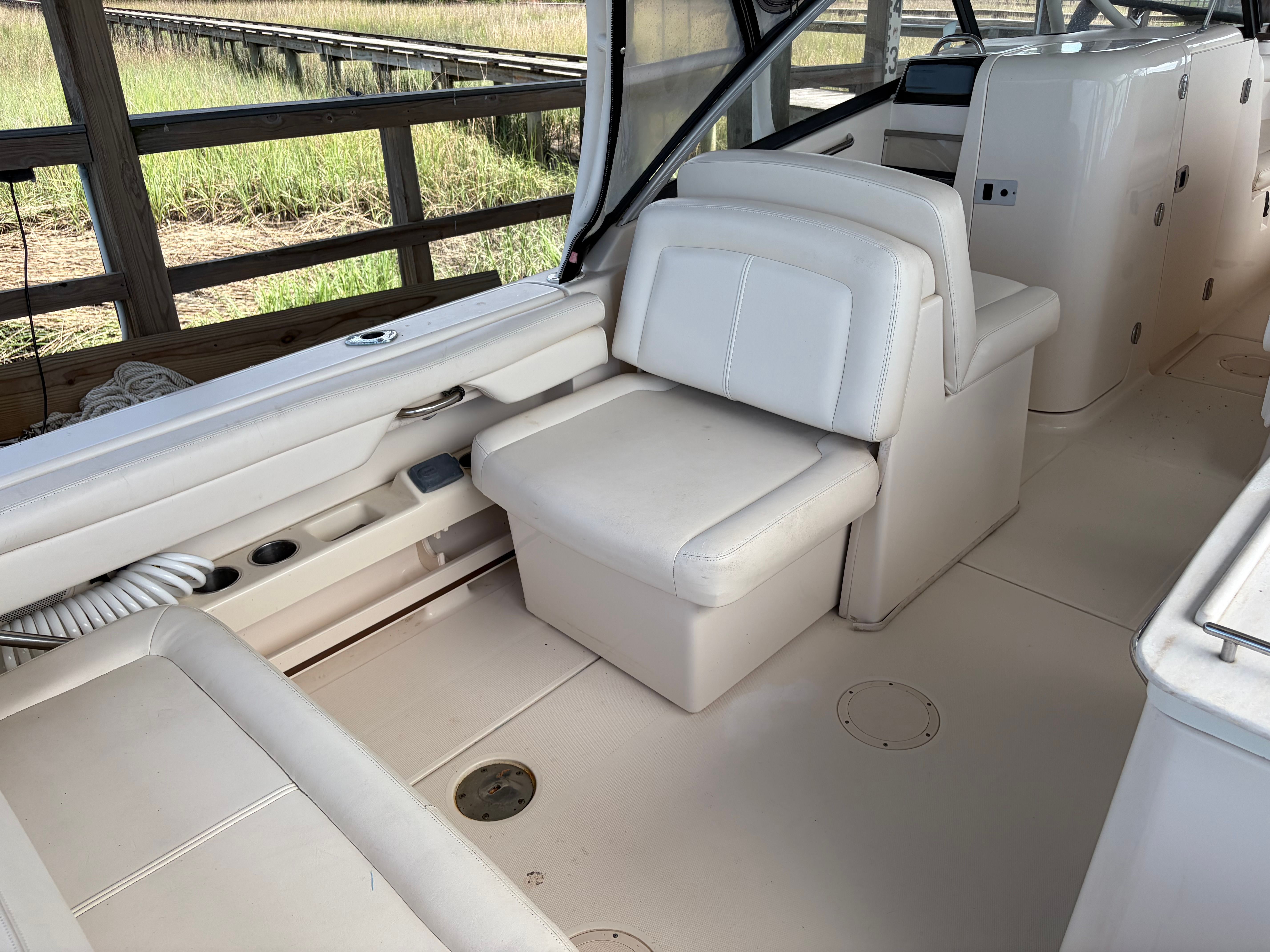 The image shows the interior of a 2016 Grady-White Freedom 275 boat with beige seating.