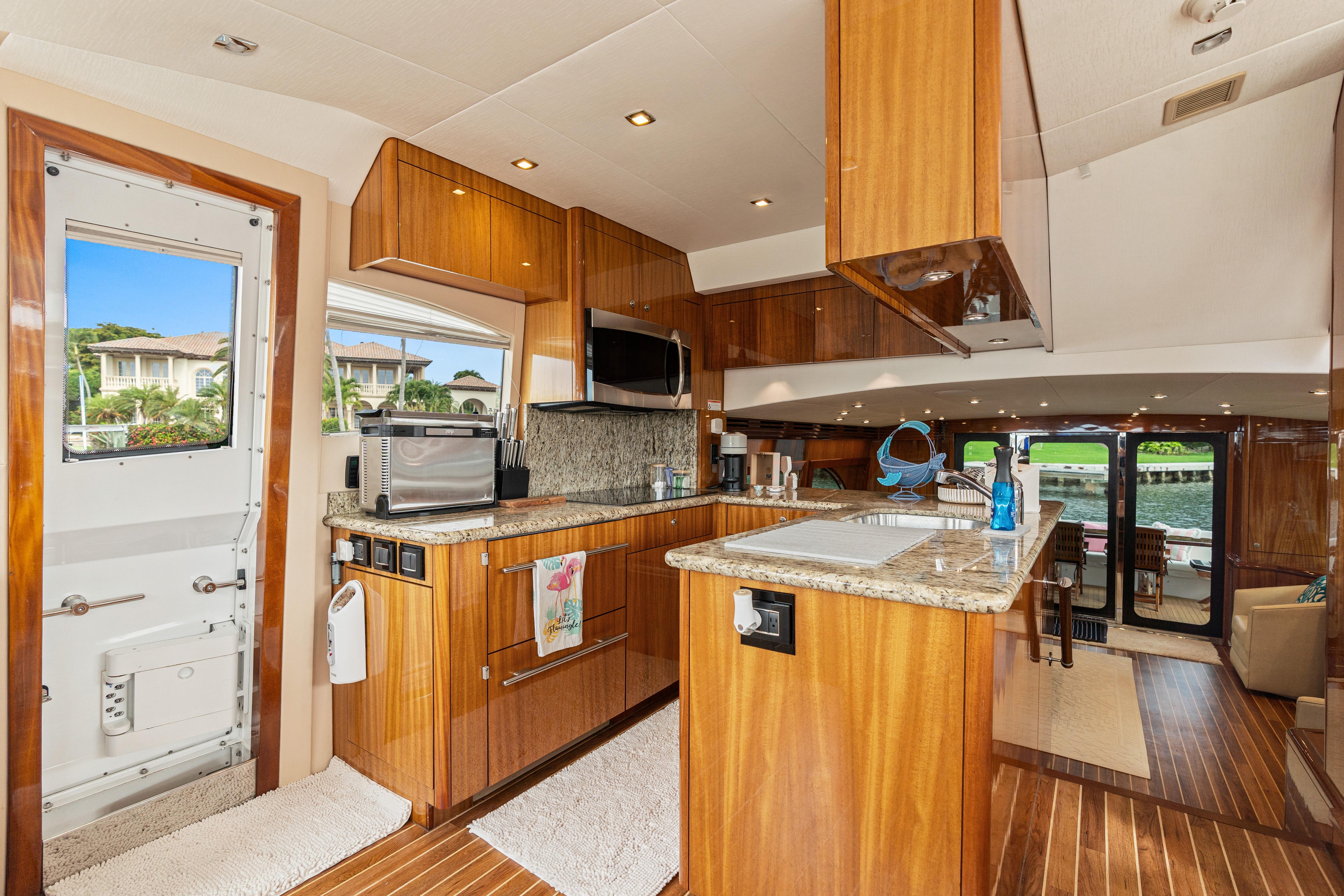 Luxurious 2008 Hatteras 64 Motor Yacht interior with modern kitchen and elegant wood finishes.