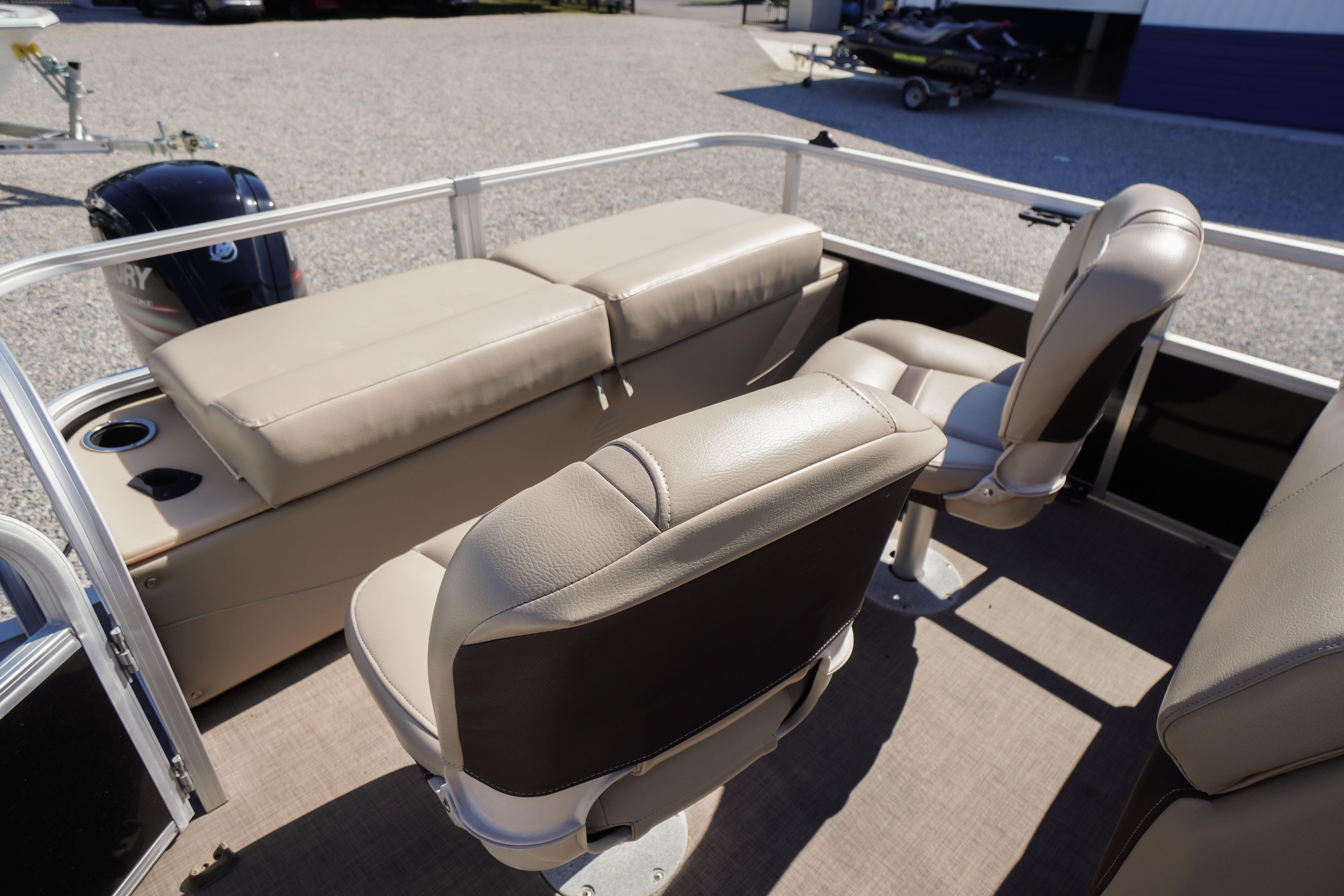 2019 SUNTRACKER Fishin' Barge 22 DLX interior with beige seating and boat engine.