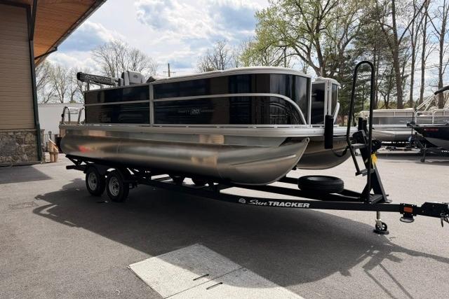 2026 Sun Tracker Party Barge 20 DLX pontoon boat on trailer, parked outdoors.