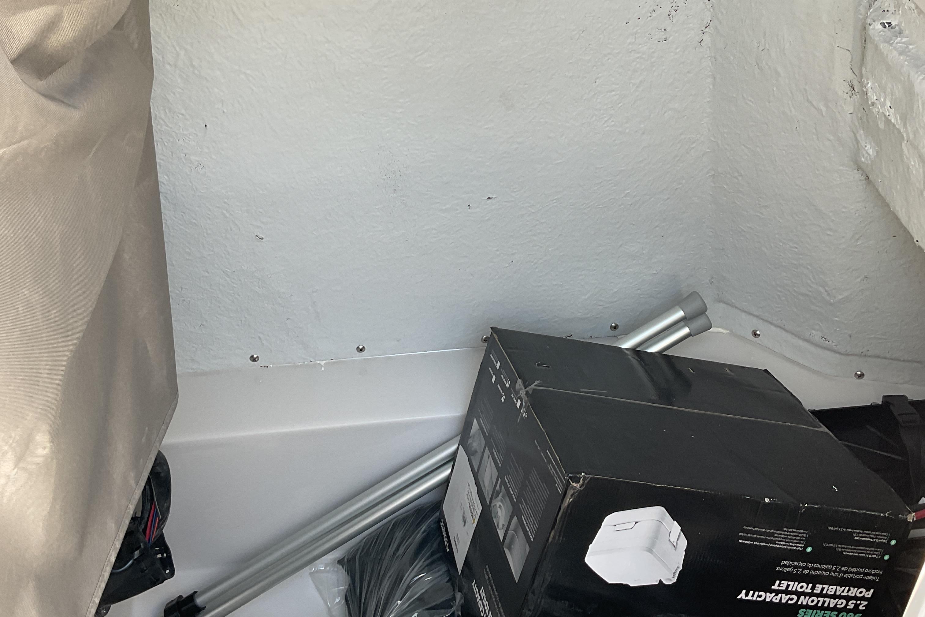 Storage area in 2026 Starcraft SVX 231 OB CC boat with portable toilet box.
