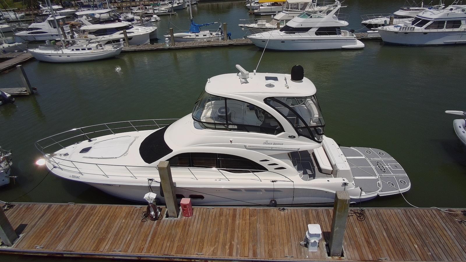 2007 Sea Ray 52 Sedan Bridge yacht docked at marina, surrounded by other boats.