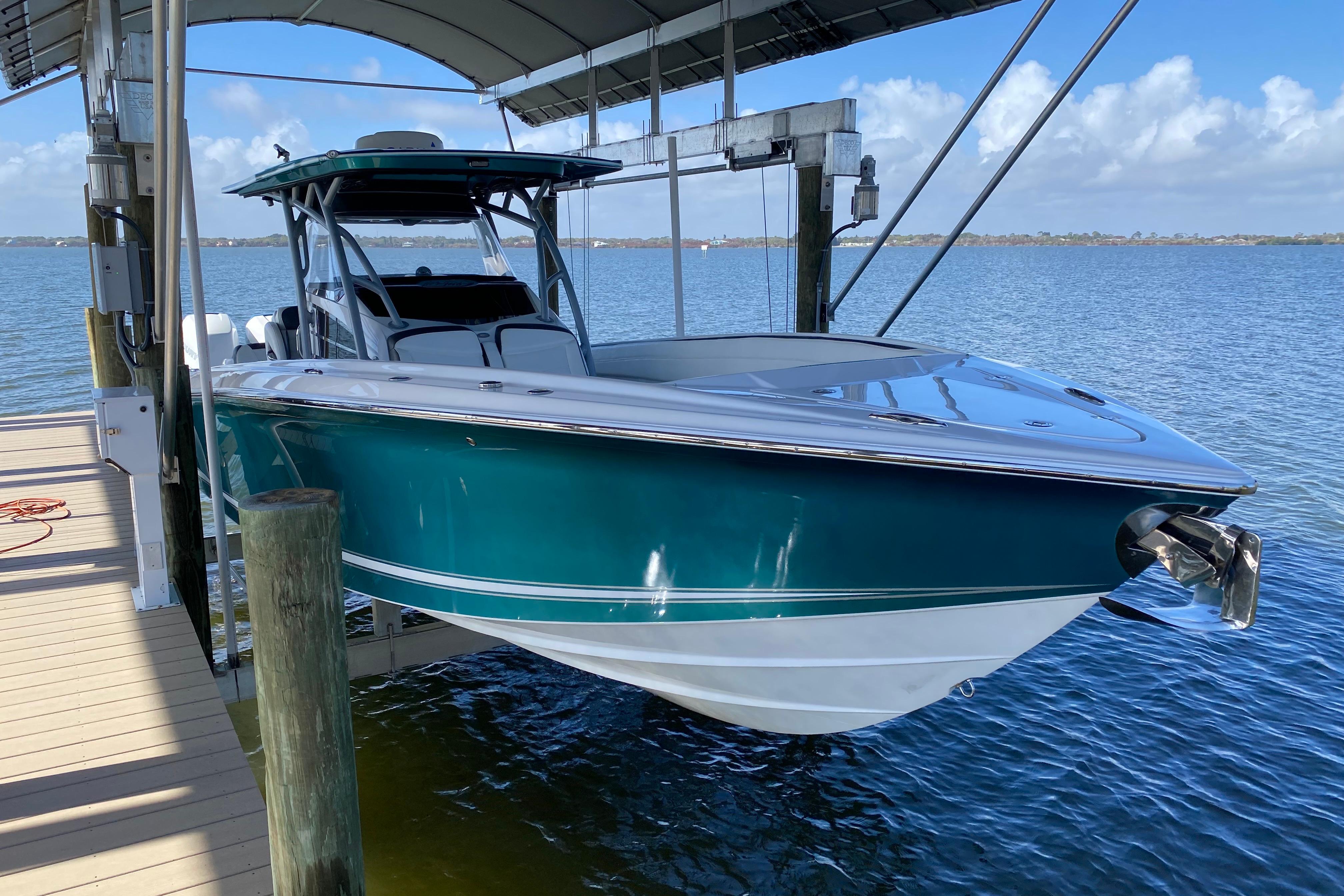2018 Nor-Tech 340 Sport Center Console boat docked on a lift over water.