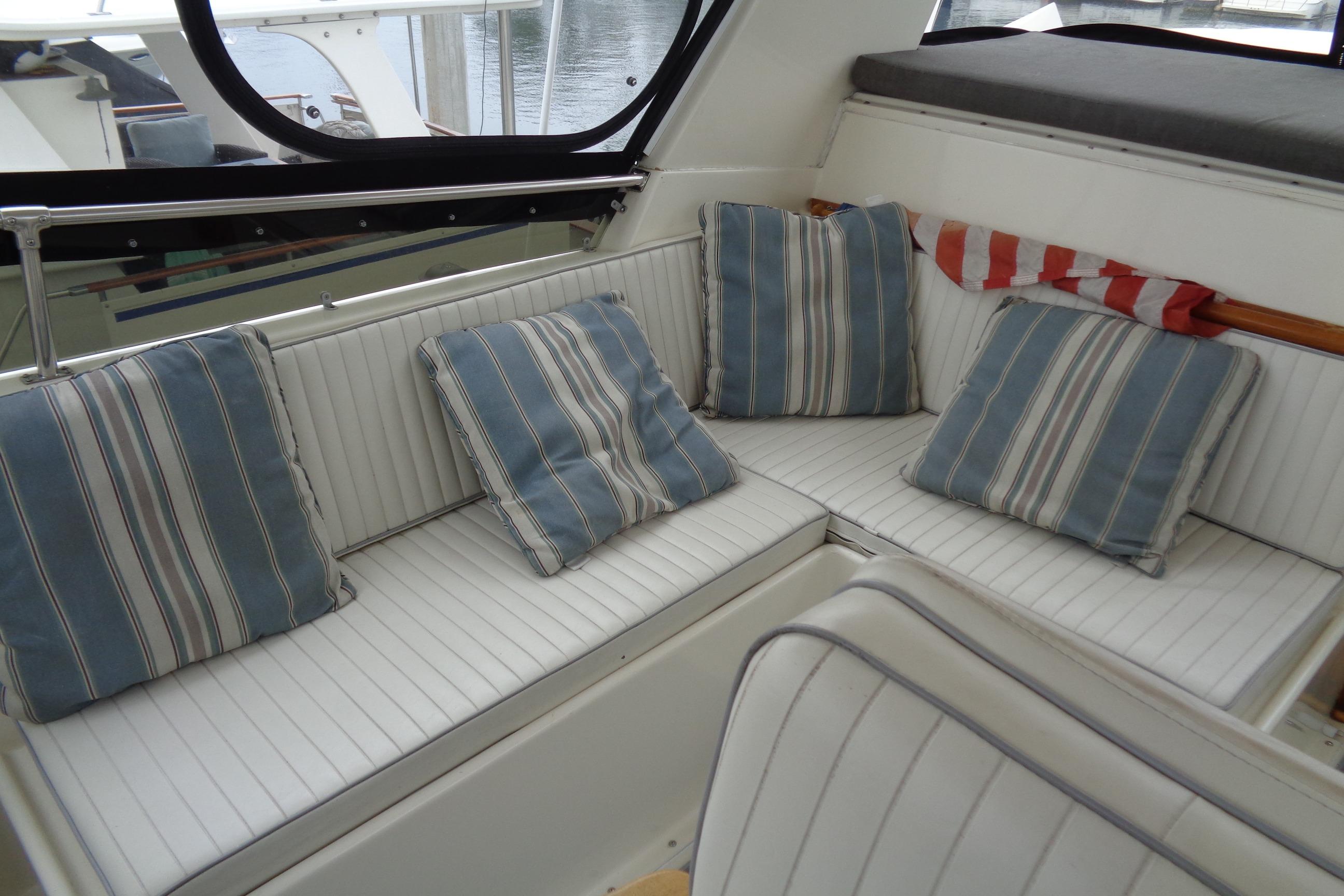 Interior seating area of 1981 Hatteras 48 Cockpit Motor Yacht with striped cushions.