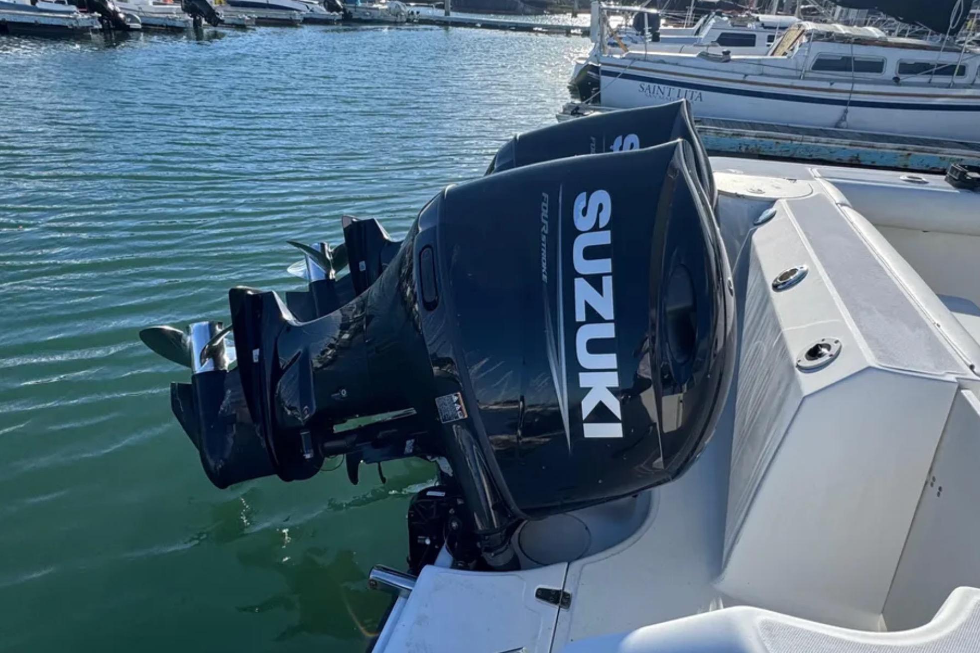 Boston Whaler 255 Conquest 2004 with Suzuki outboard motors docked at marina.