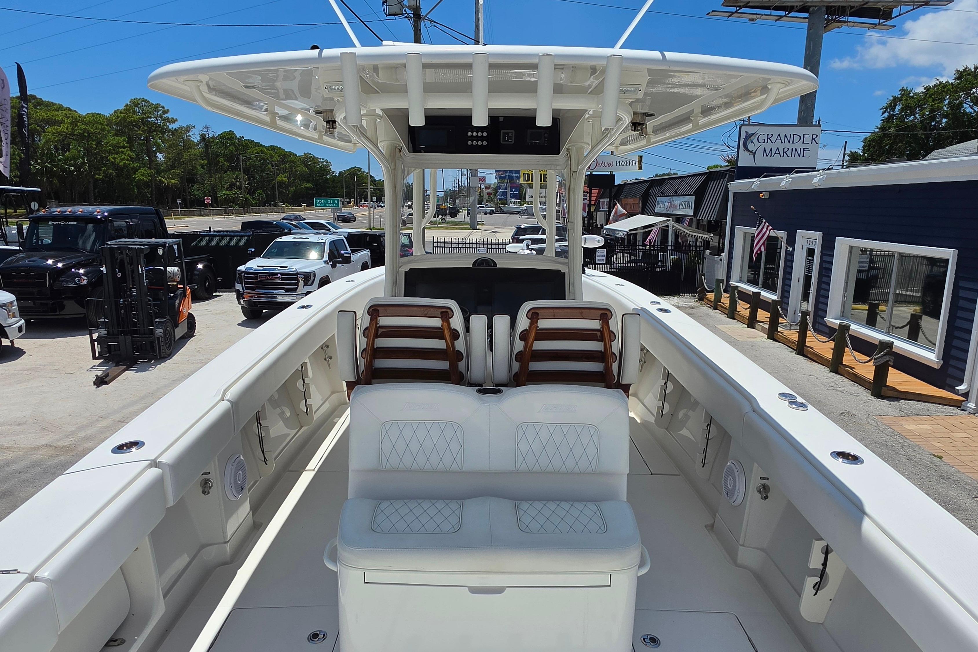 2020 Jupiter 34 HFS boat interior with seating, parked at a marina dealership.