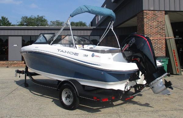 2023 Tahoe 185 S boat with outboard motor, parked on a trailer outside a building.
