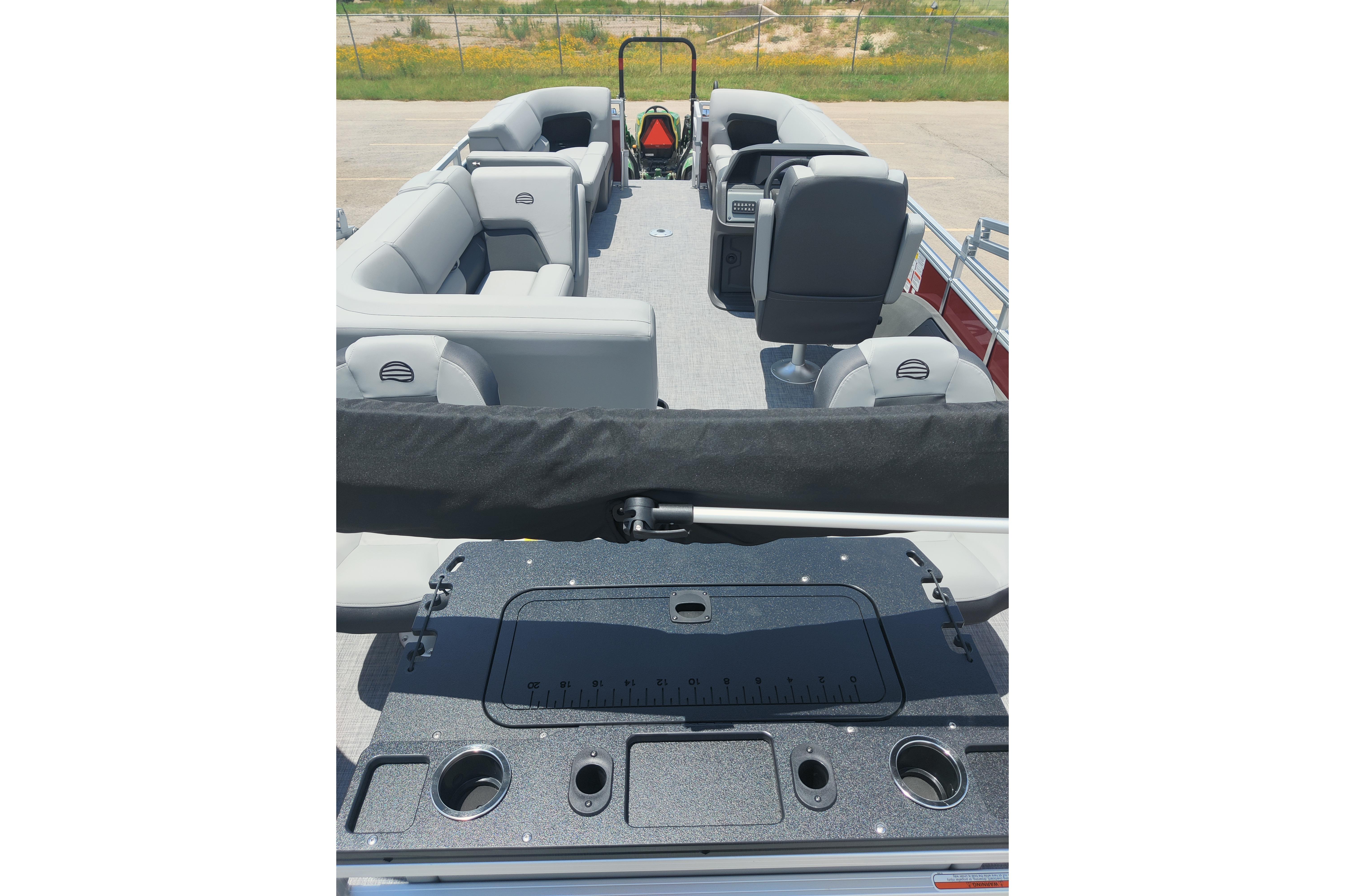 2026 Sun Tracker SportFish 22 DLX pontoon boat interior with seating and fishing station.