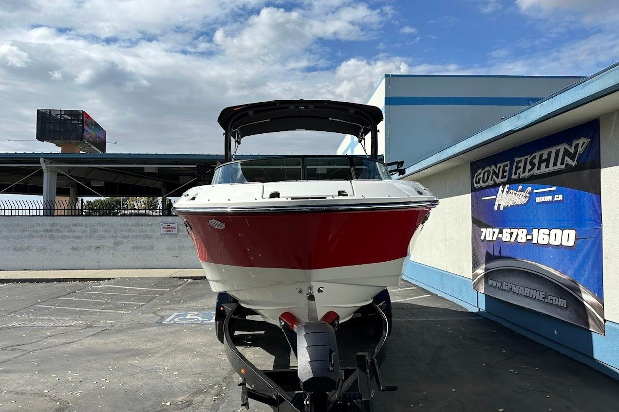 2026 Sea Ray SDX 230 Surf boat on trailer at dealership, sunny day.