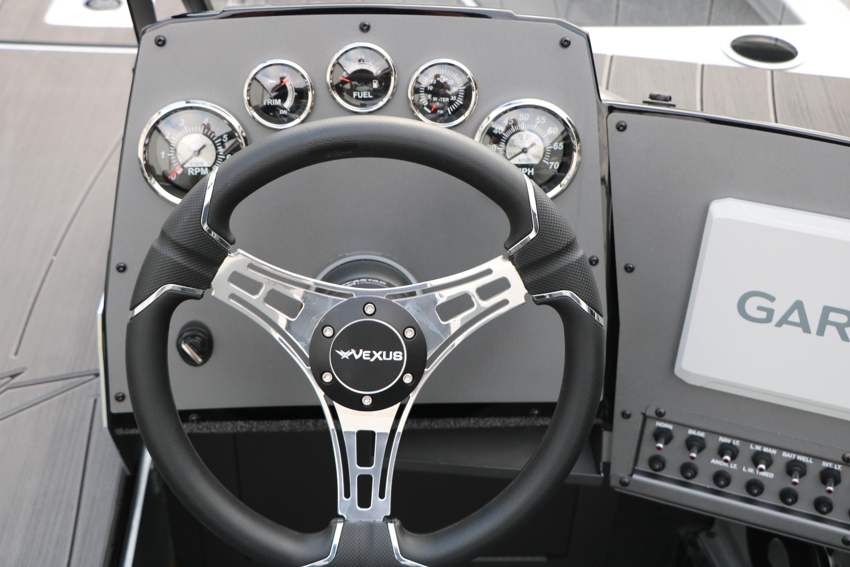 Steering wheel and dashboard of 2026 Vexus ADX 190 boat with gauges and controls.