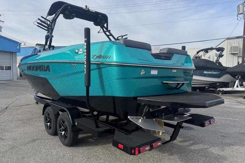 2026 Moomba Tykon boat on trailer, teal color, parked outdoors.