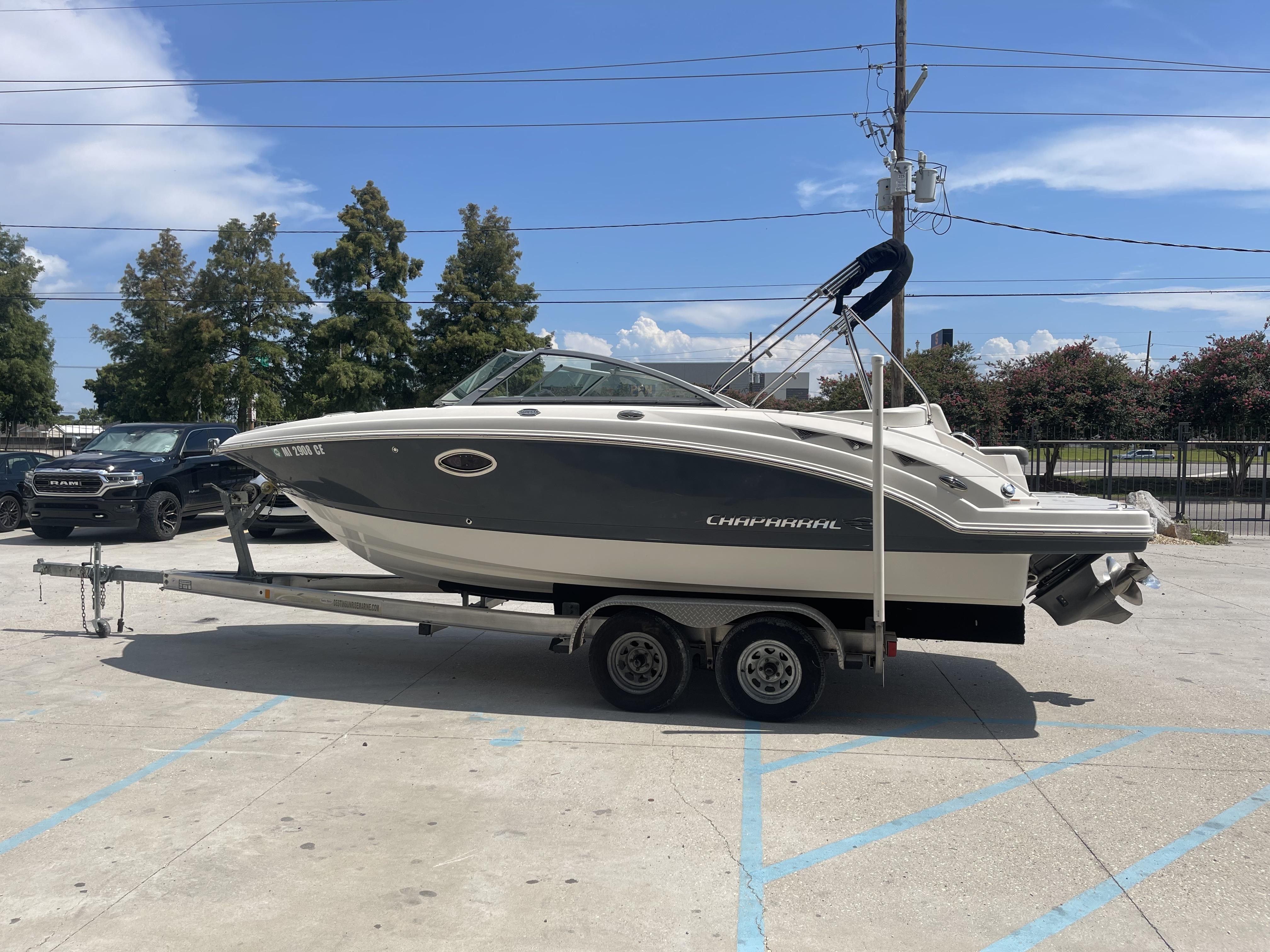 2014 Chaparral Sunesta 224 boat on trailer in parking lot.