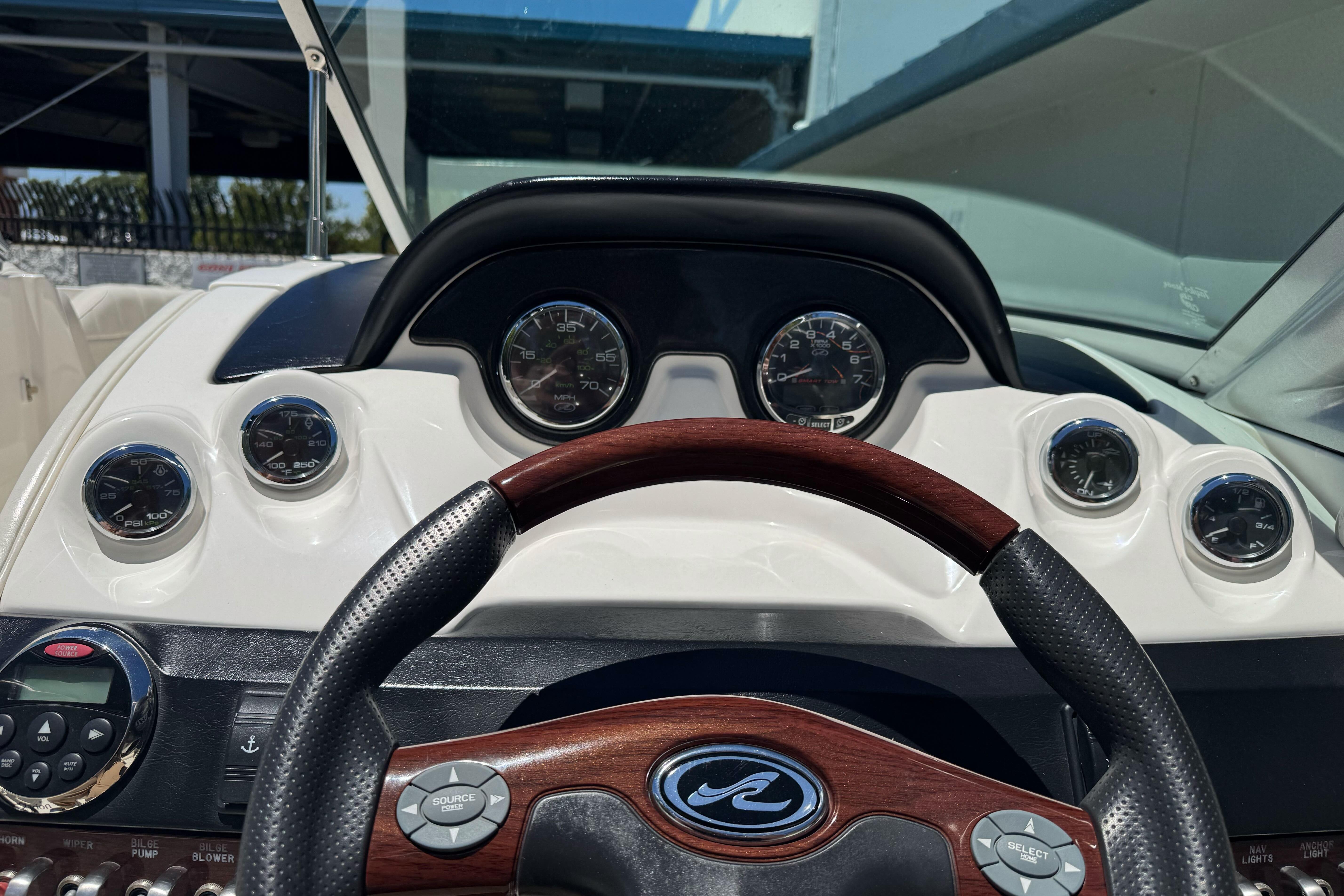 Dashboard of a 2007 Sea Ray SLX 250 boat with gauges and steering wheel.